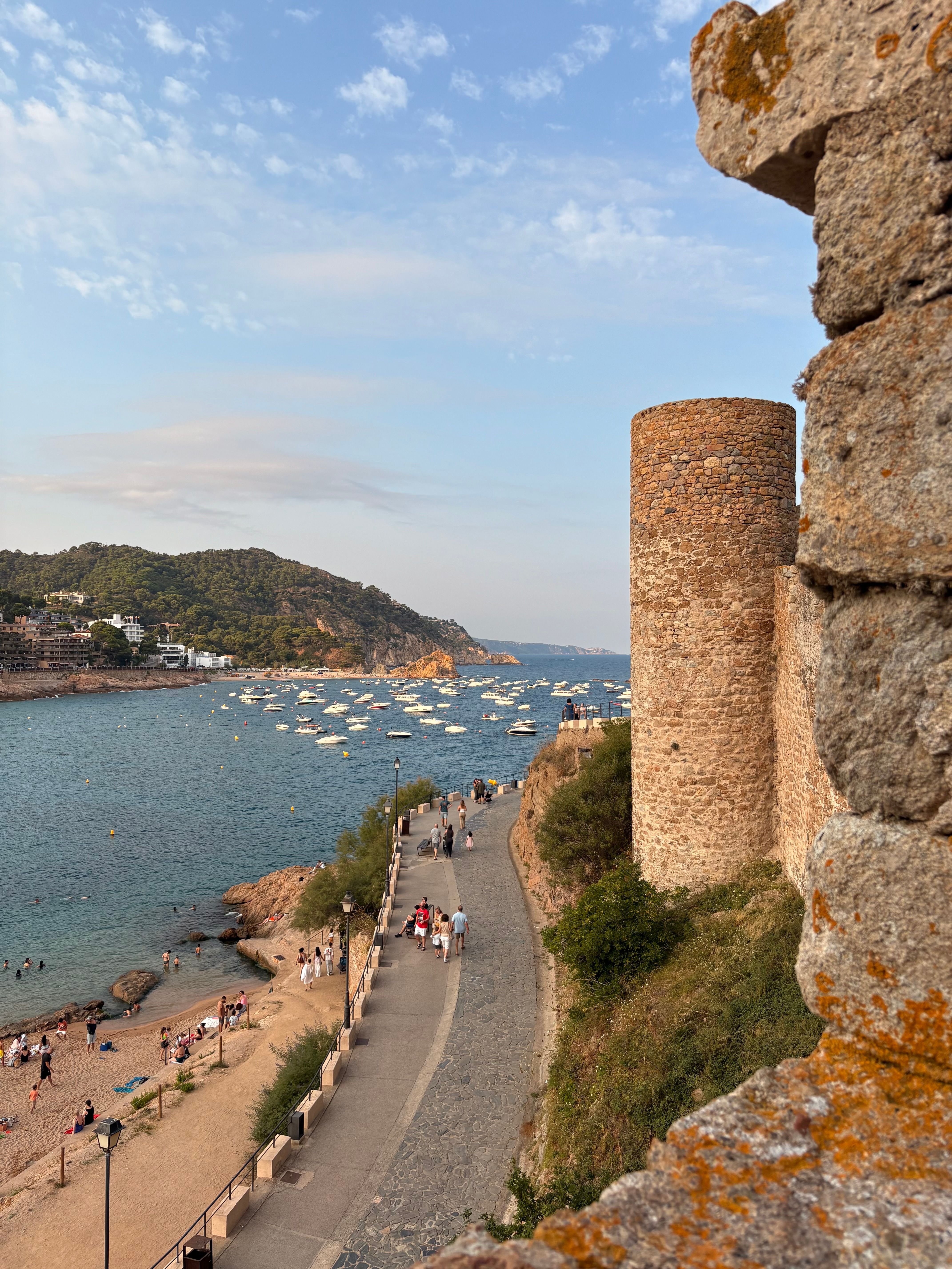 A classic Costa Brava cove — turquoise water, whitewashed village, pine cliffs (e.g. Calella de Palafrugell or Tossa de Mar)