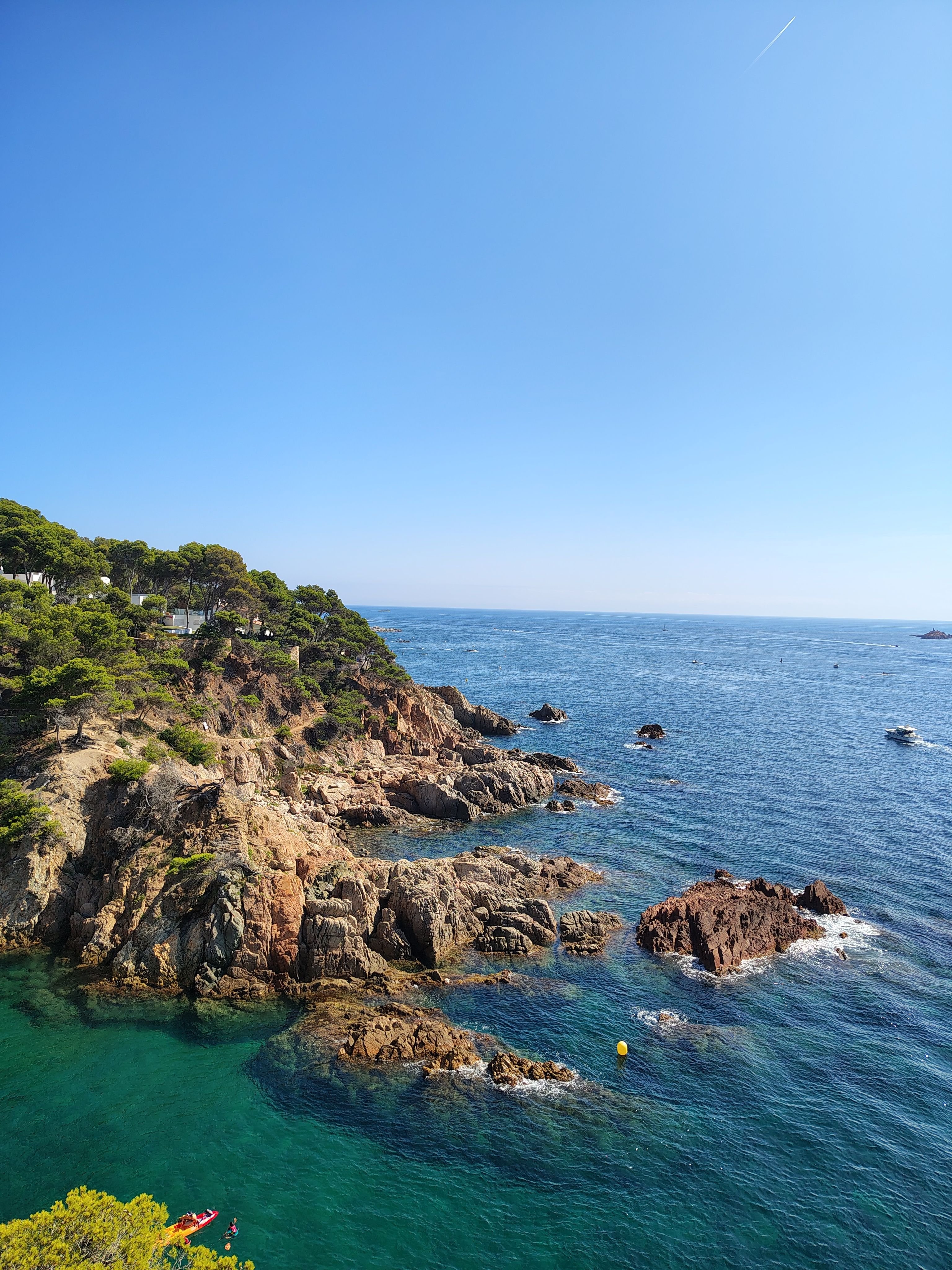 Coastal footpath (camí de ronda) along the cliffs, or Tossa de Mar's Vila Vella walls above the beach