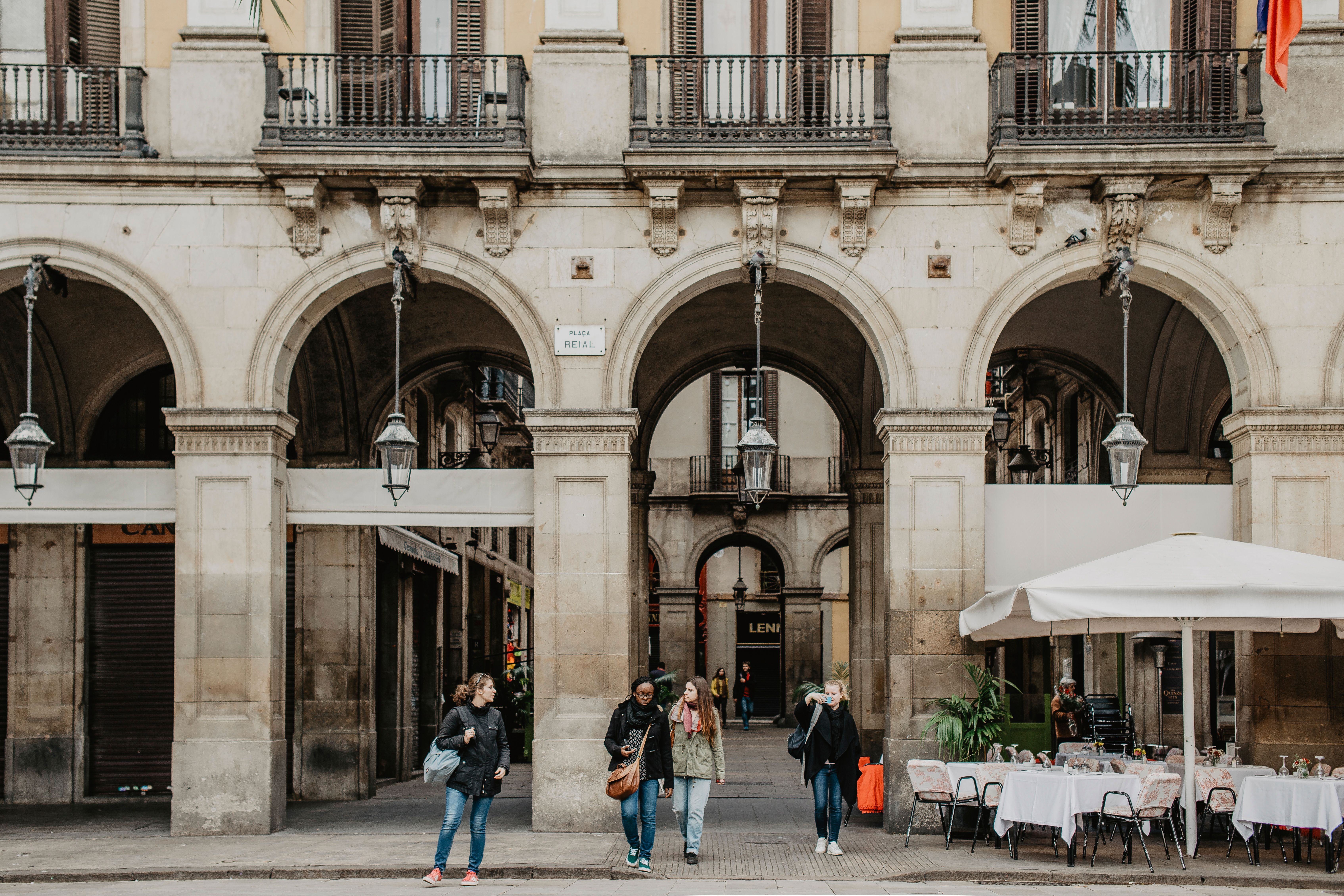 A lively Gràcia plaça with cafe terraces and locals, village atmosphere