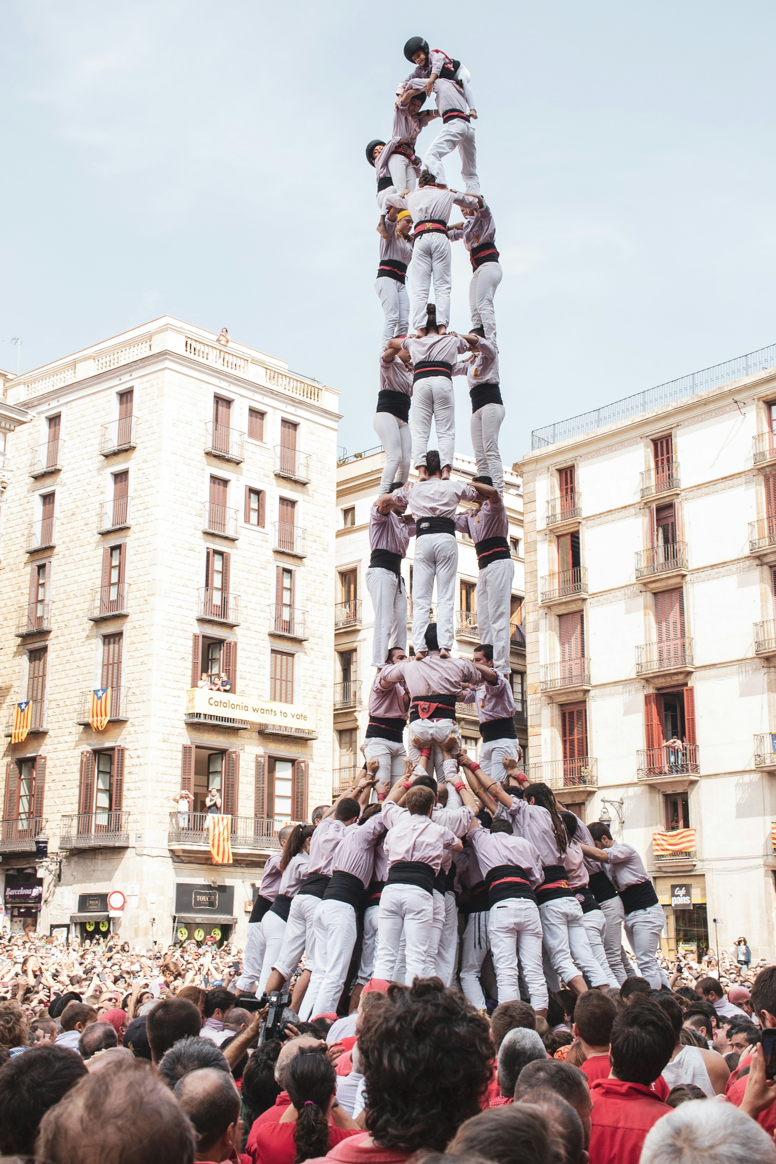 A warm everyday cultural scene — a café terrace, a market exchange, or a plaça gathering