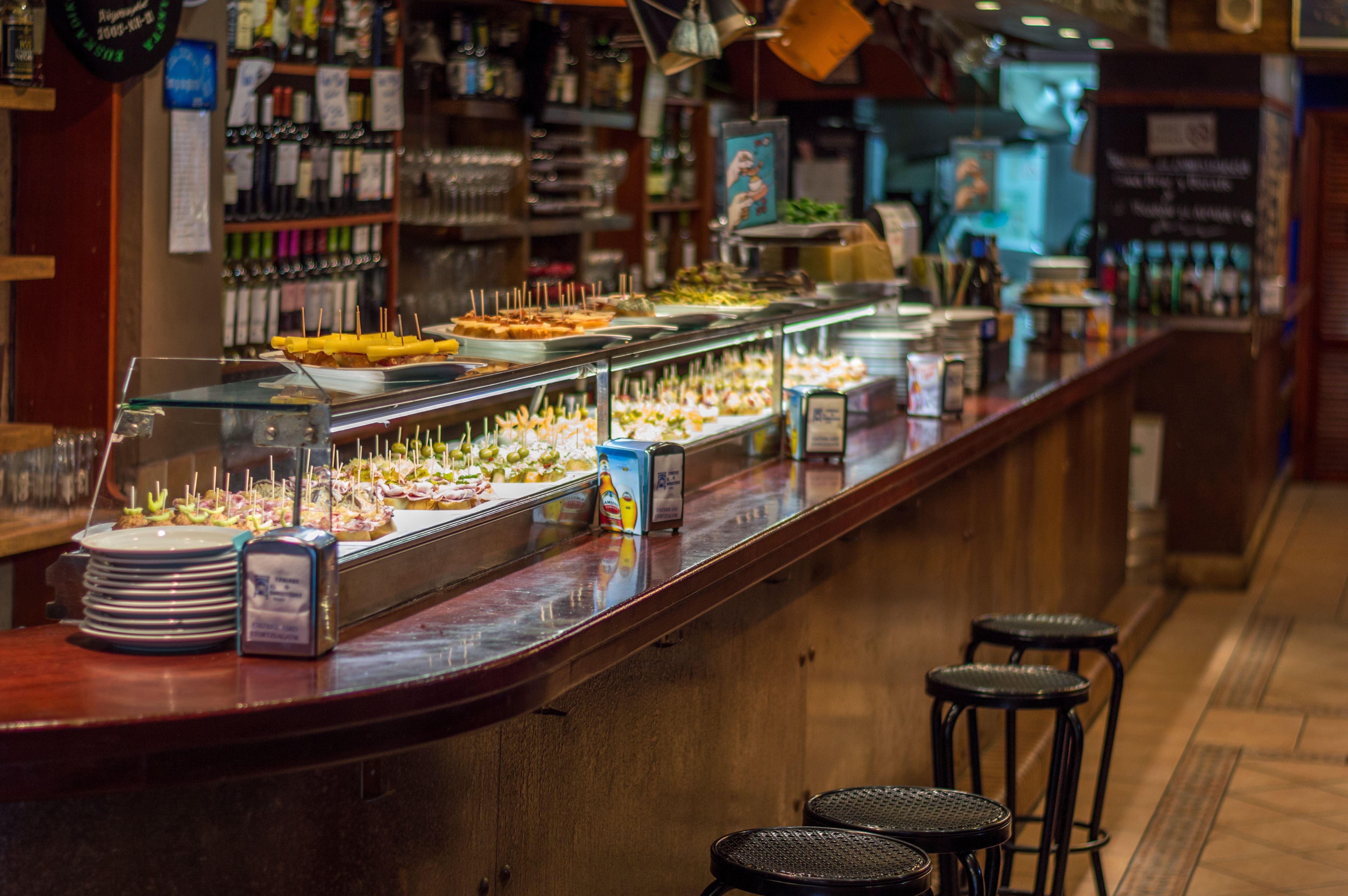 A close-up of specific tapas — patatas bravas, jamón, or pintxos with toothpicks