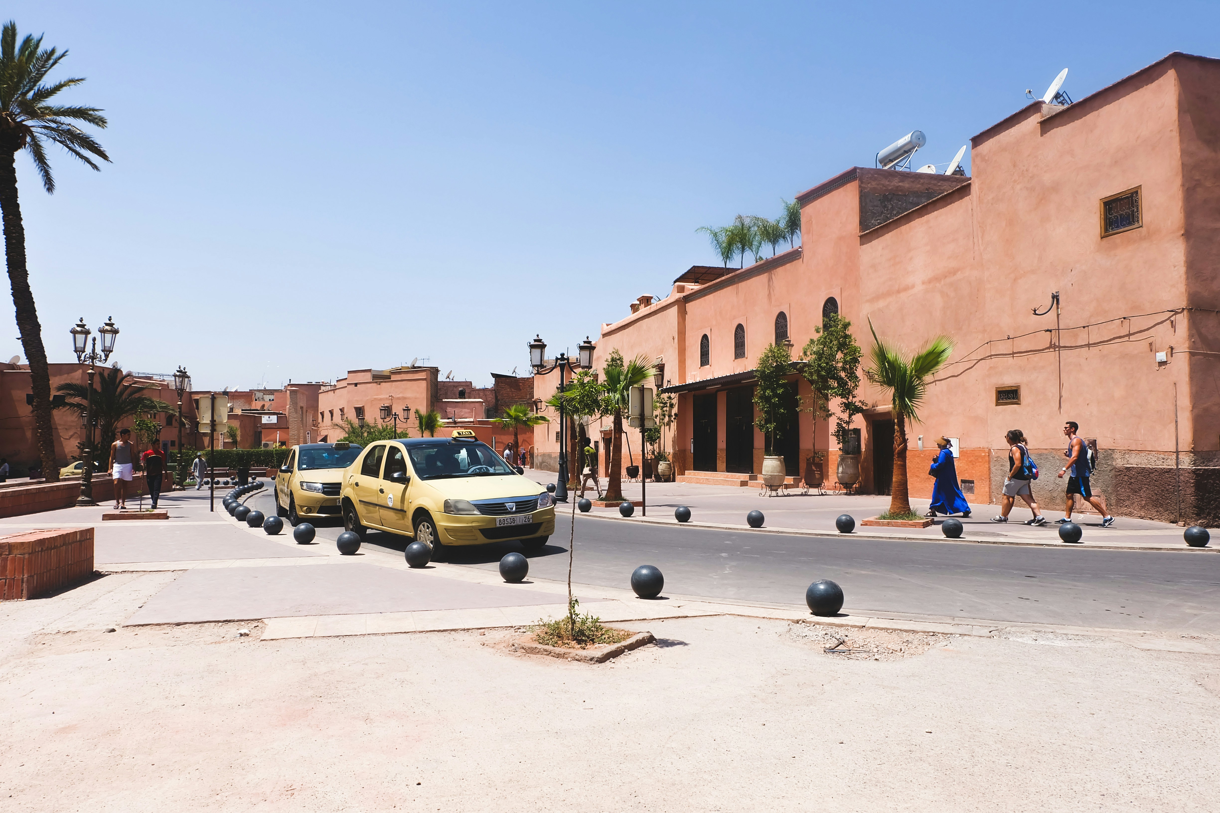 A row of petit taxis waiting on a Moroccan city street