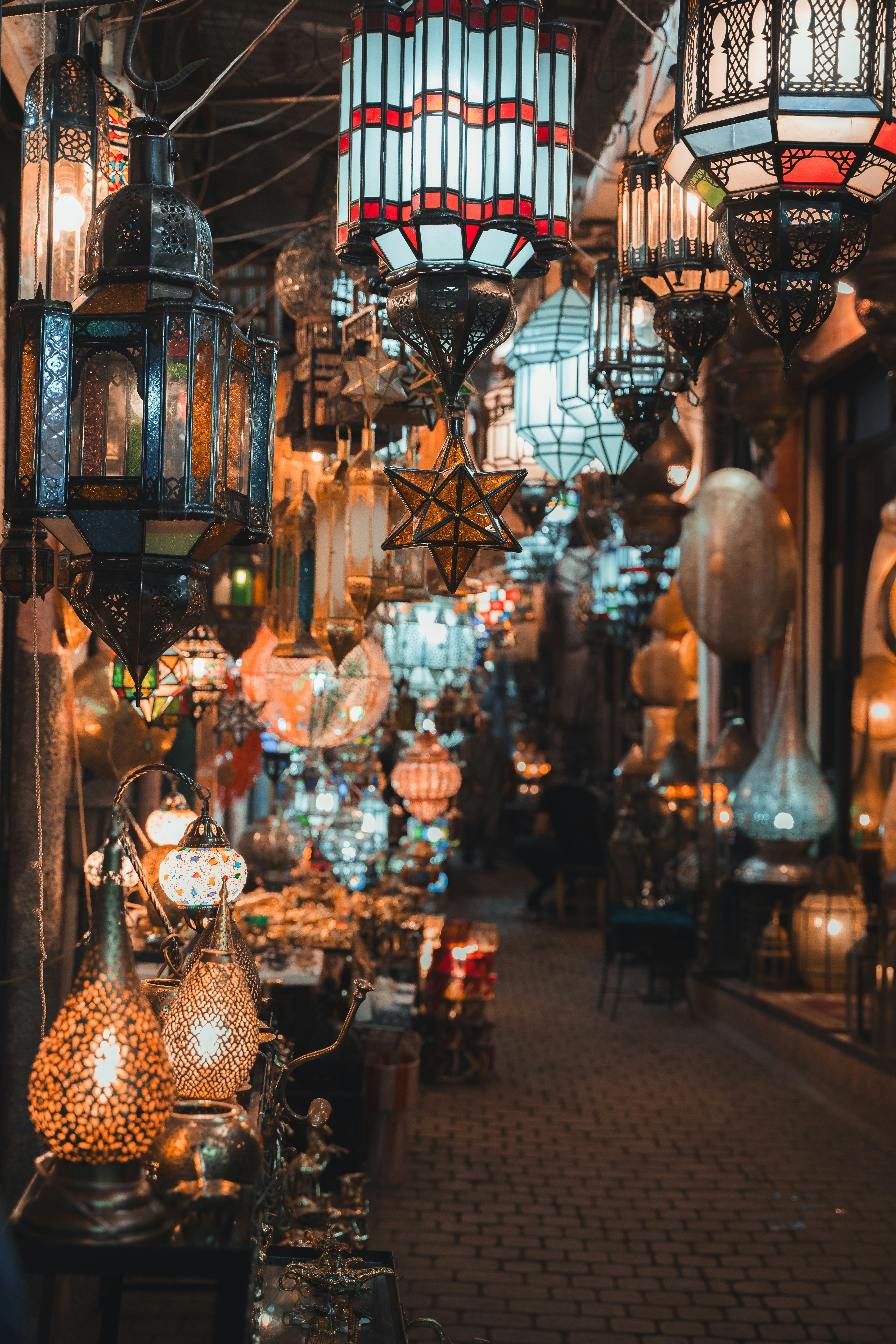 A shopkeeper and customer talking over brass lanterns in a Marrakech market