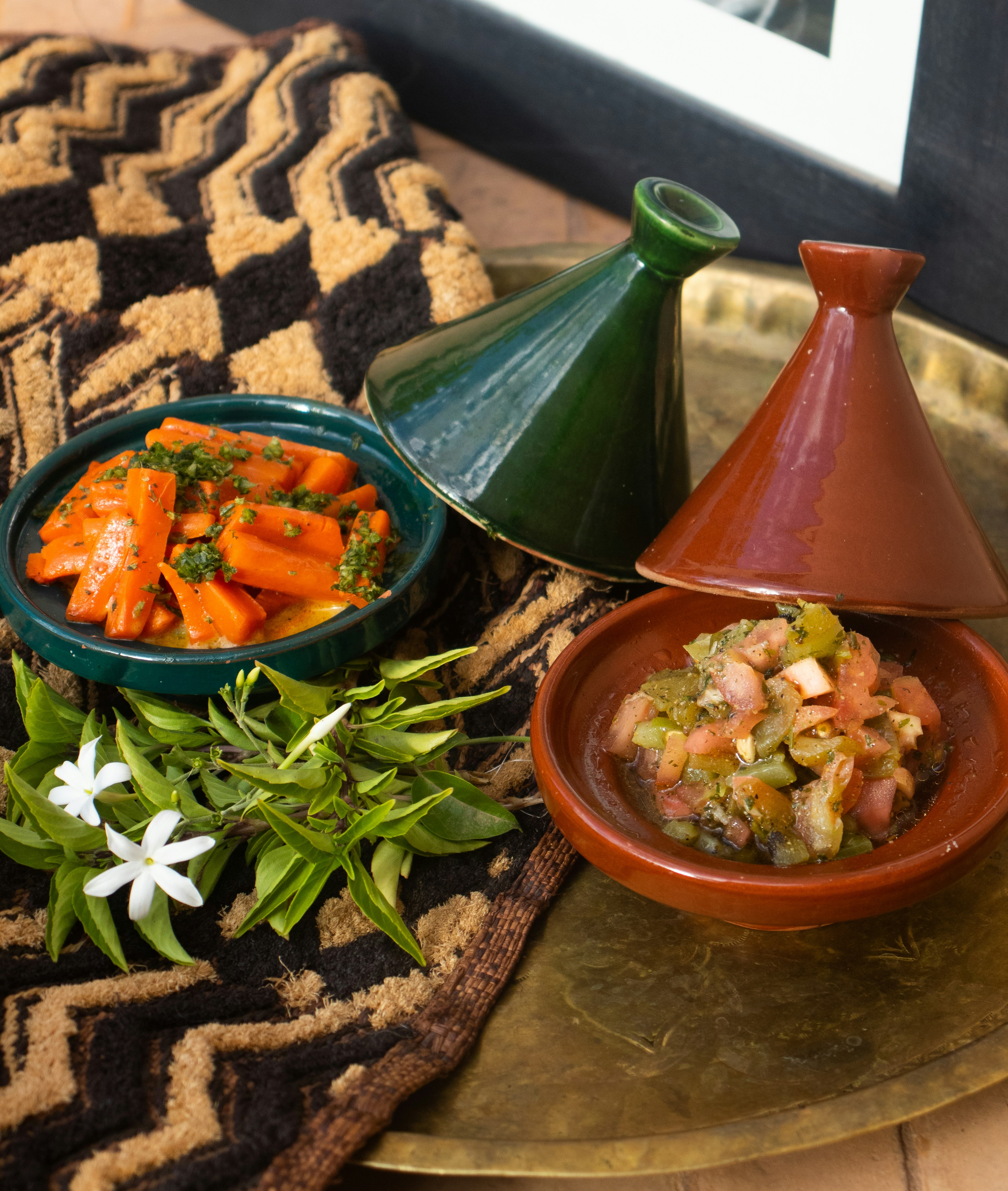 A traditional Moroccan lamb tagine with vegetables in a conical clay pot