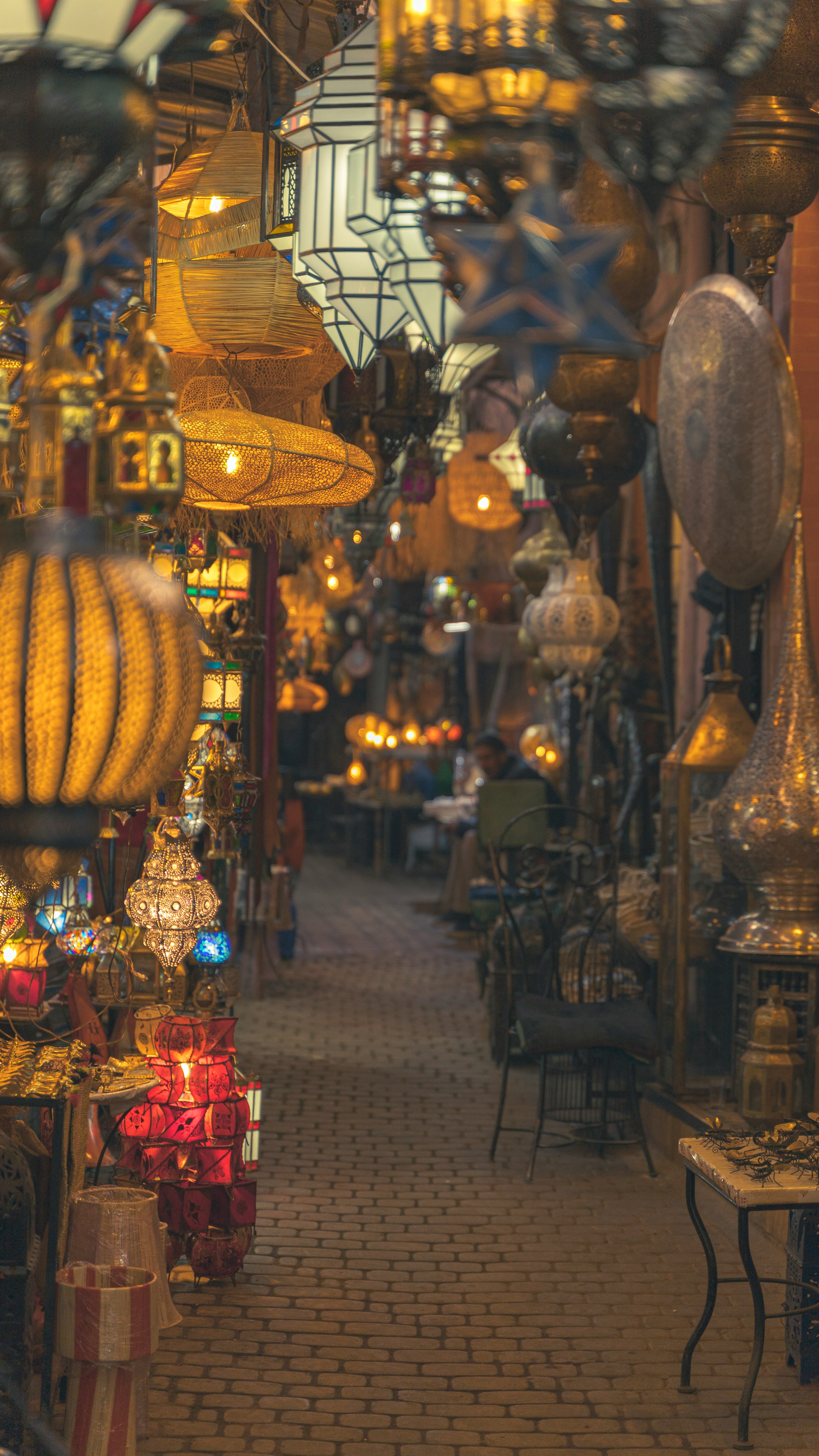 Traveler walking through a narrow, lantern-lined souk alley