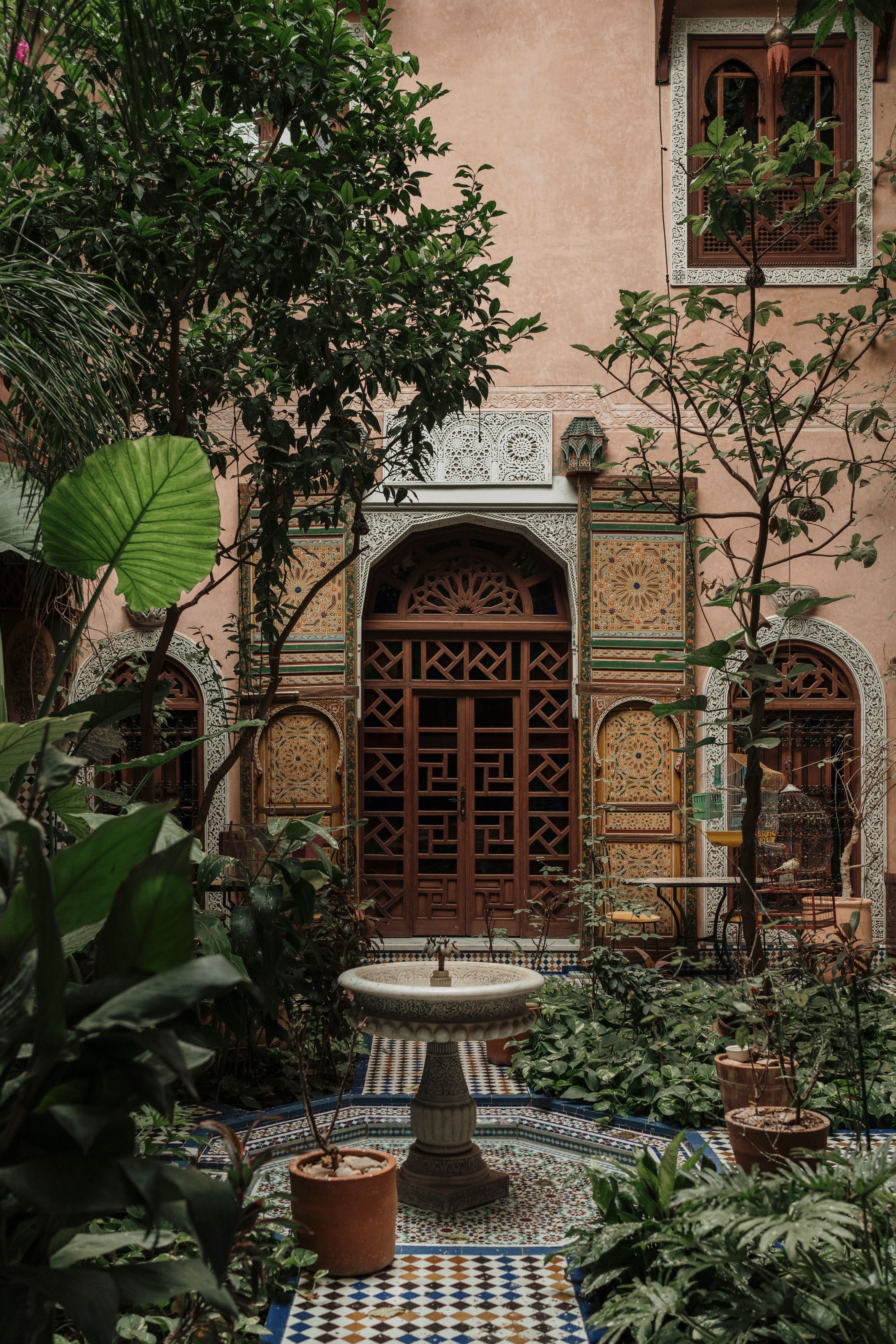 Interior courtyard of a traditional Moroccan riad with a central fountain and zellij tilework