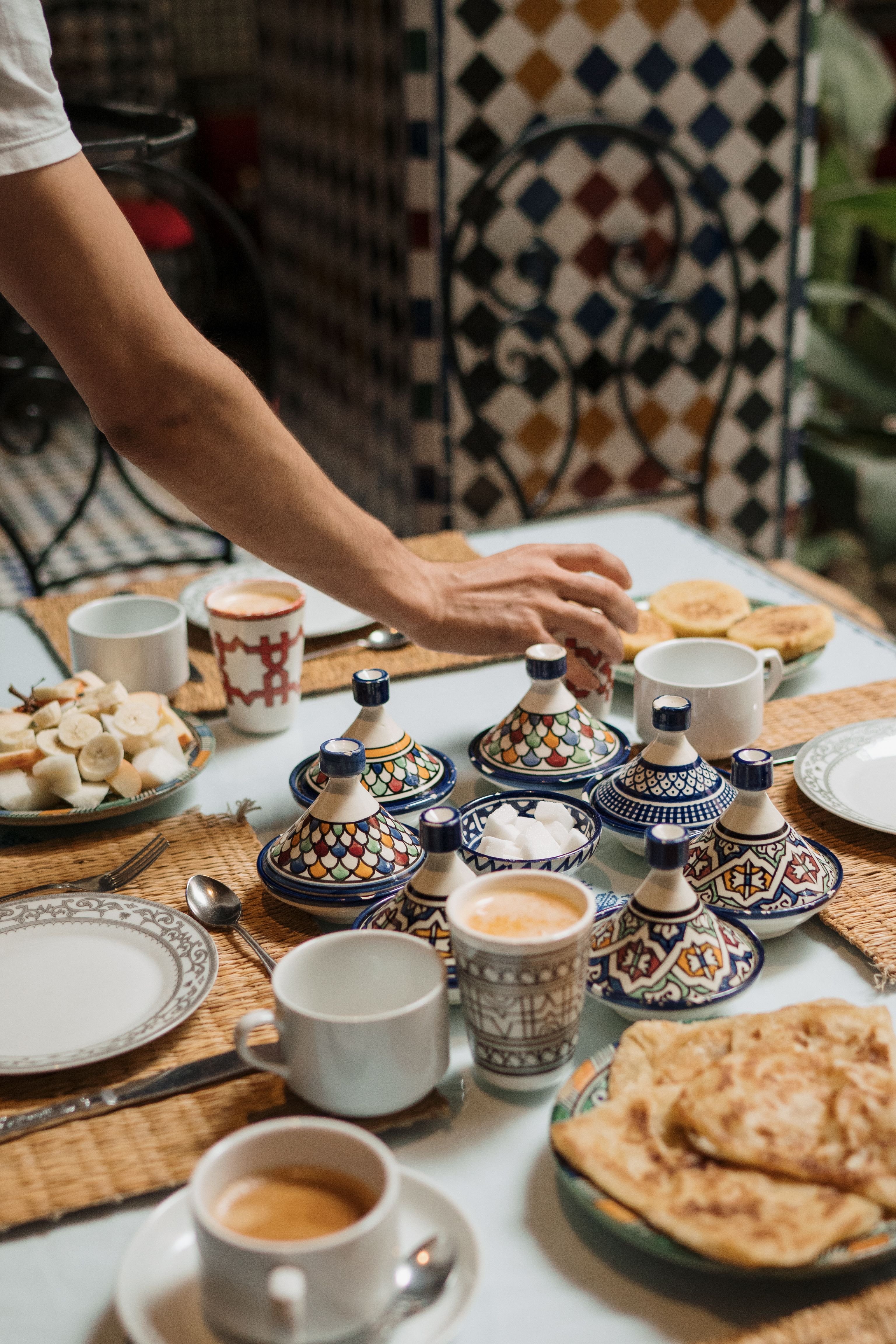 Rooftop terrace of a riad set for breakfast overlooking a medina