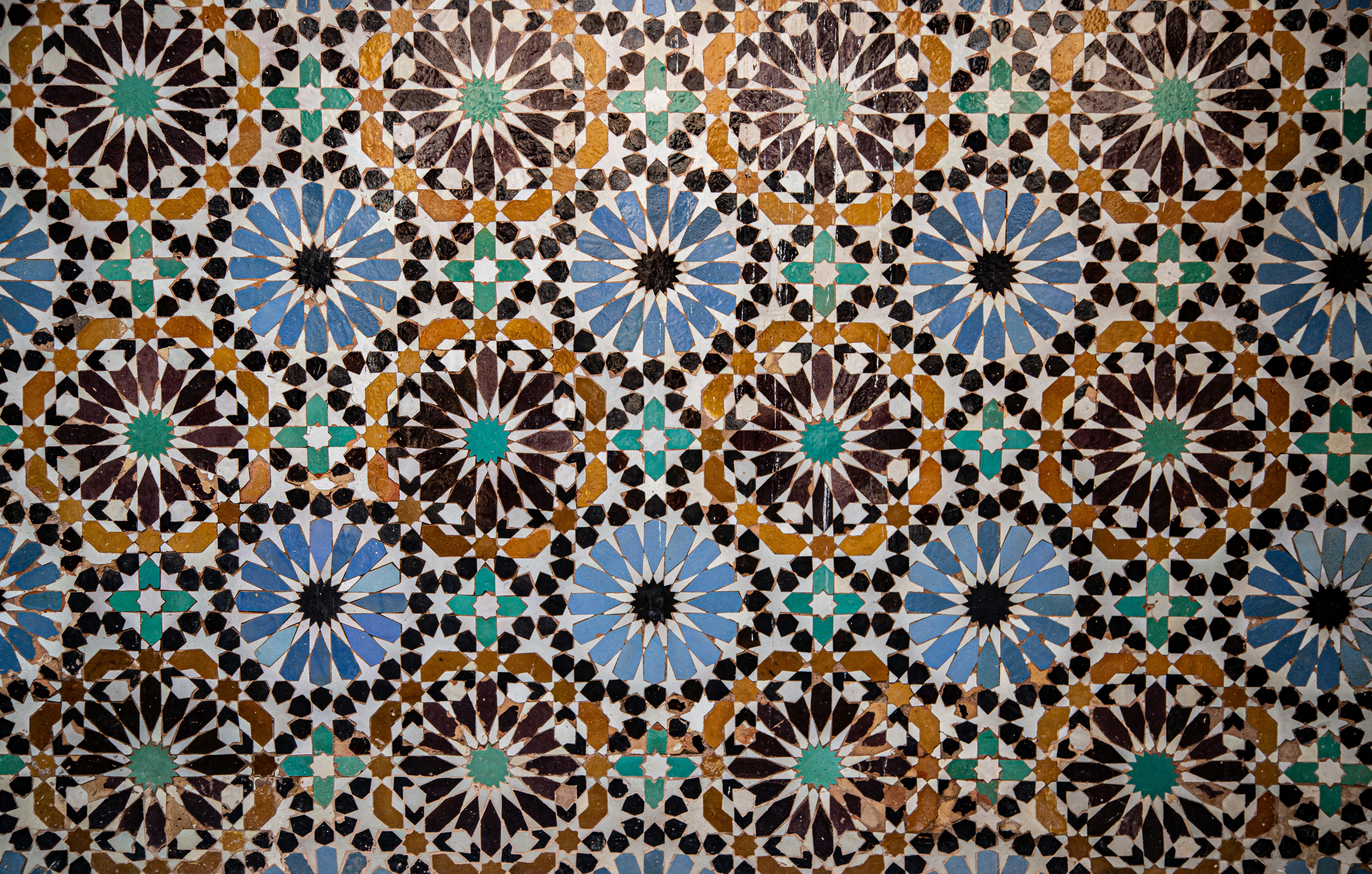 Detailed zellij tilework and carved stucco inside a Marrakech madrasa