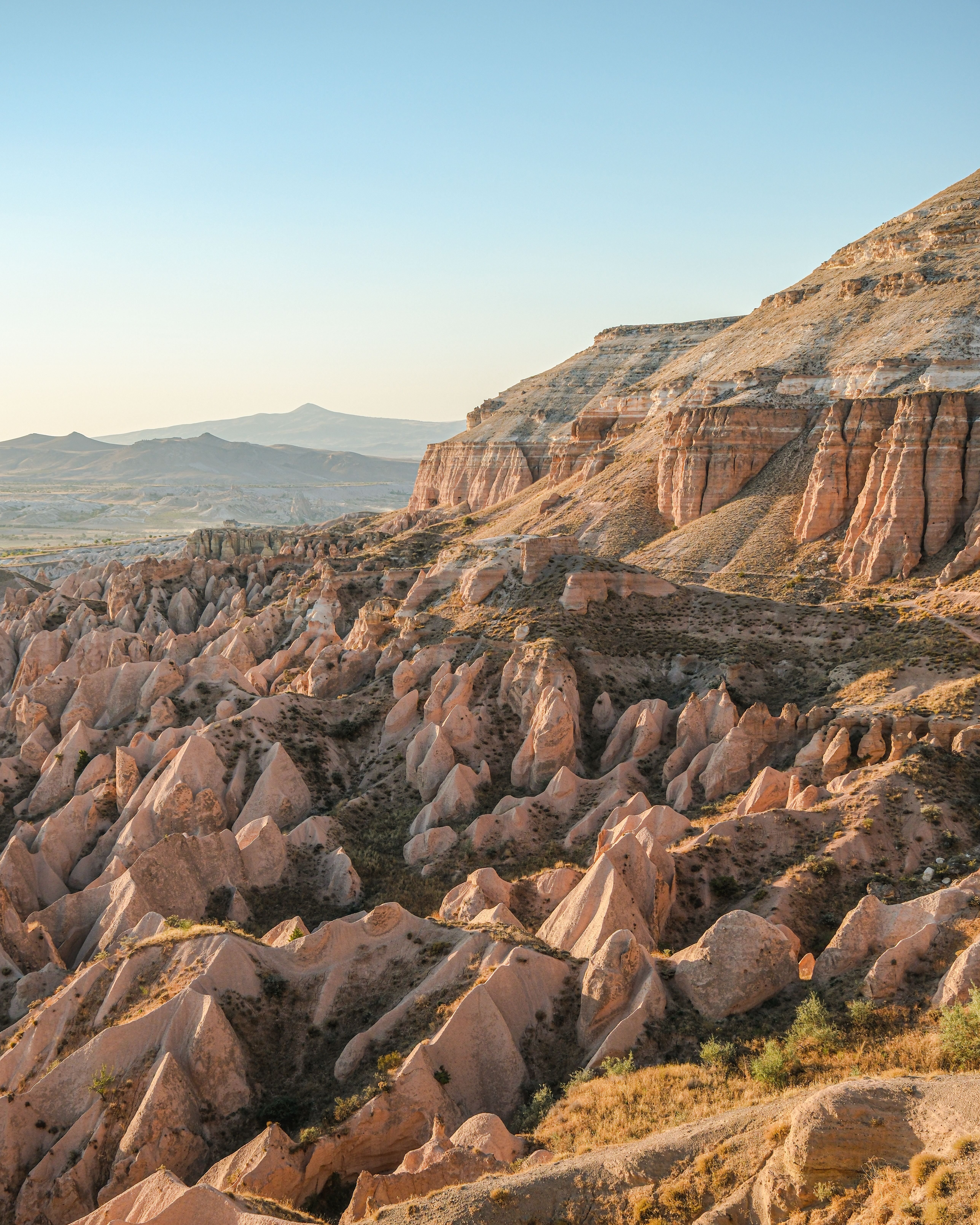 Sunrise over the Goreme valley with balloons aloft and fairy chimneys below