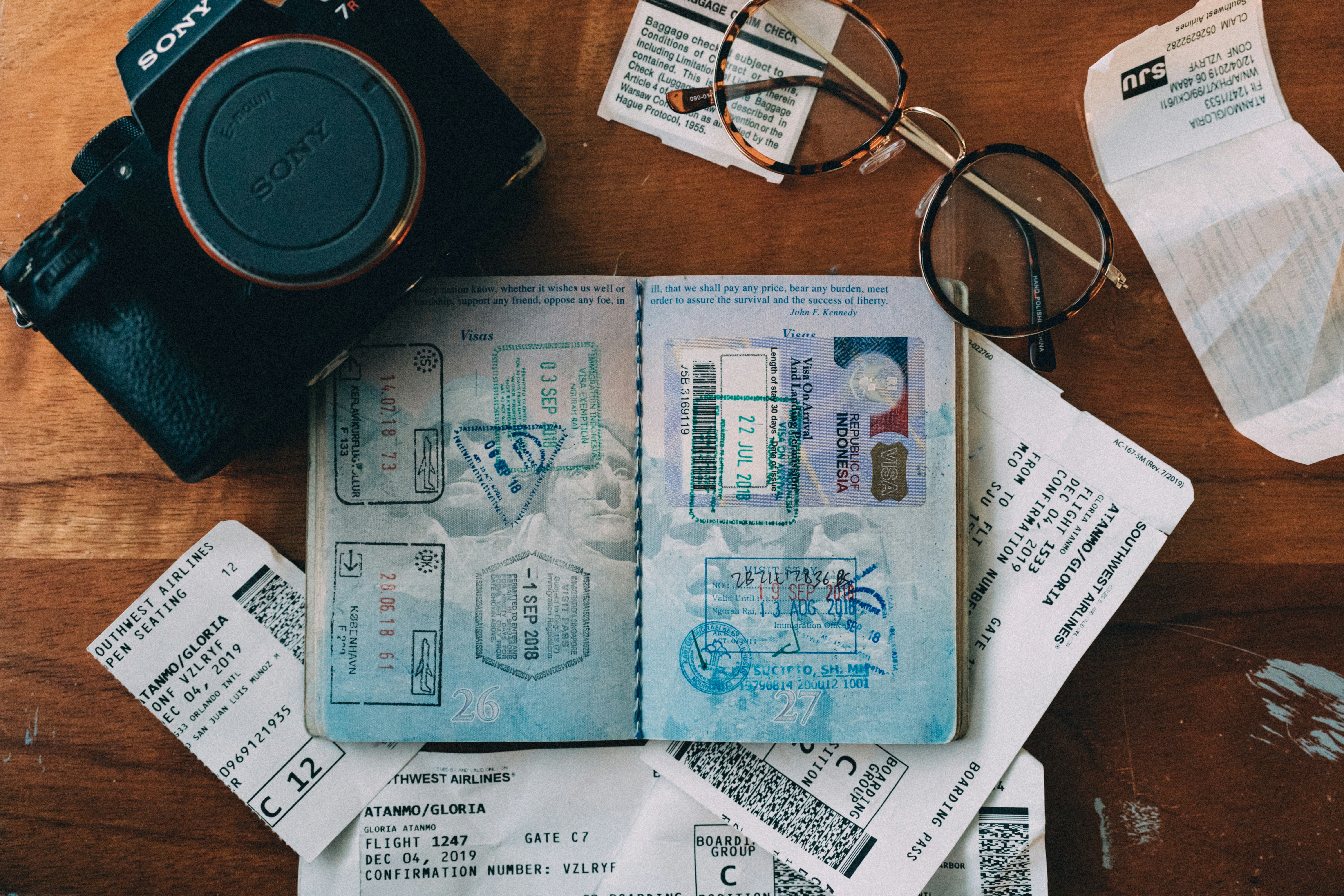 A US passport with a boarding pass, travel-planning flat lay, no recognizable faces