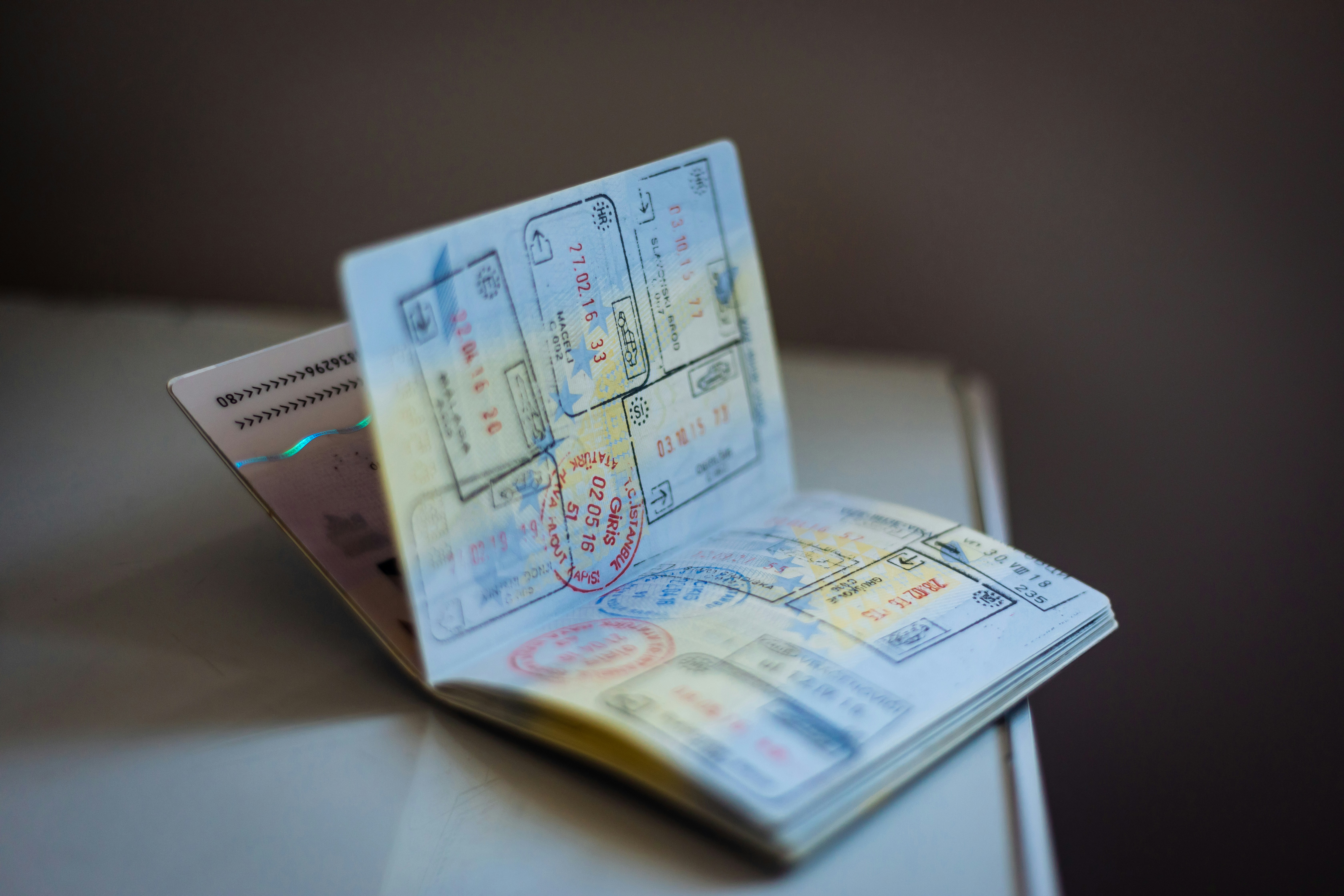 A traveler checking a passport expiration date, planning documents on a desk