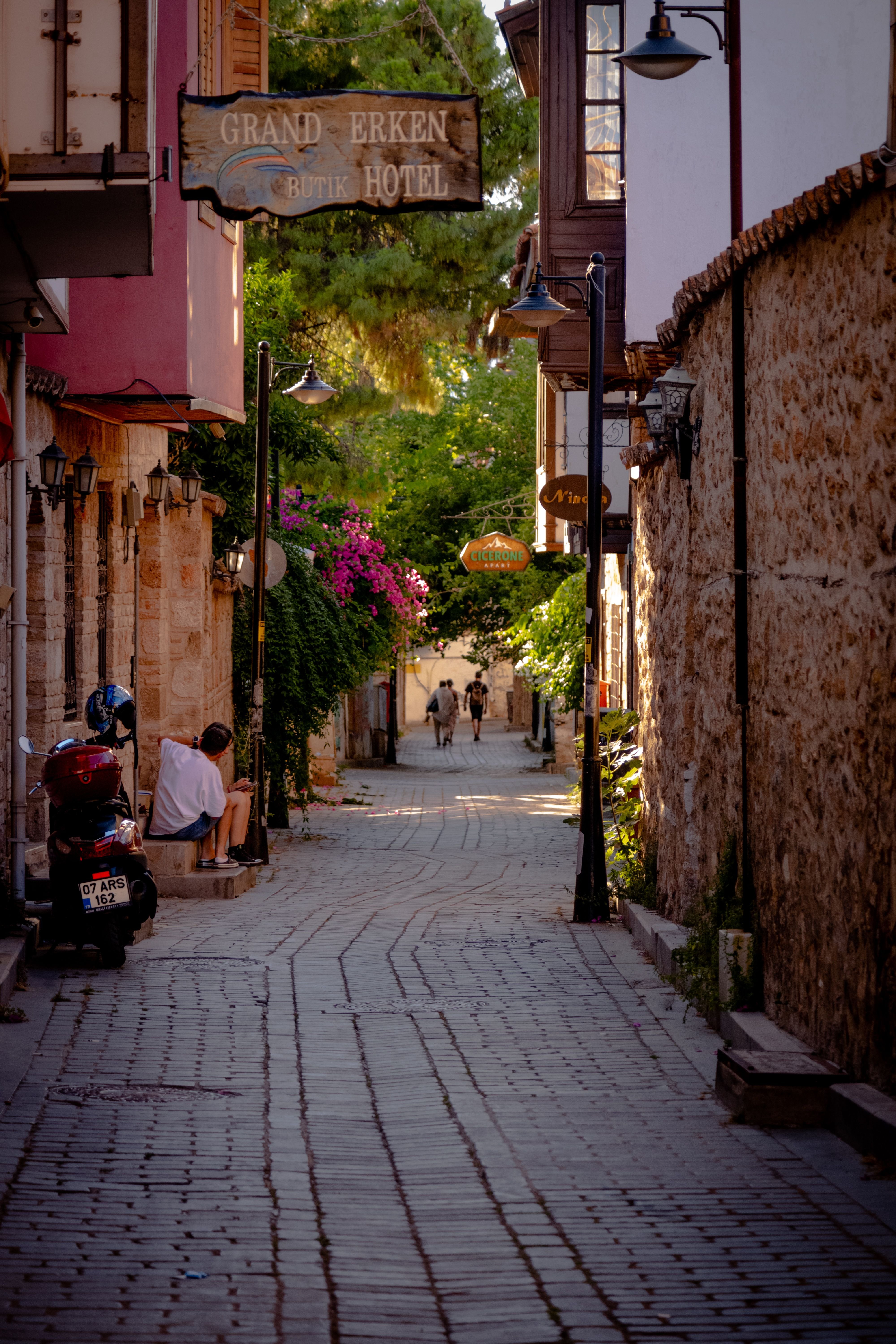 Antalya's Kaleiçi old harbor with boats and the old town walls above, mountains behind, no faces