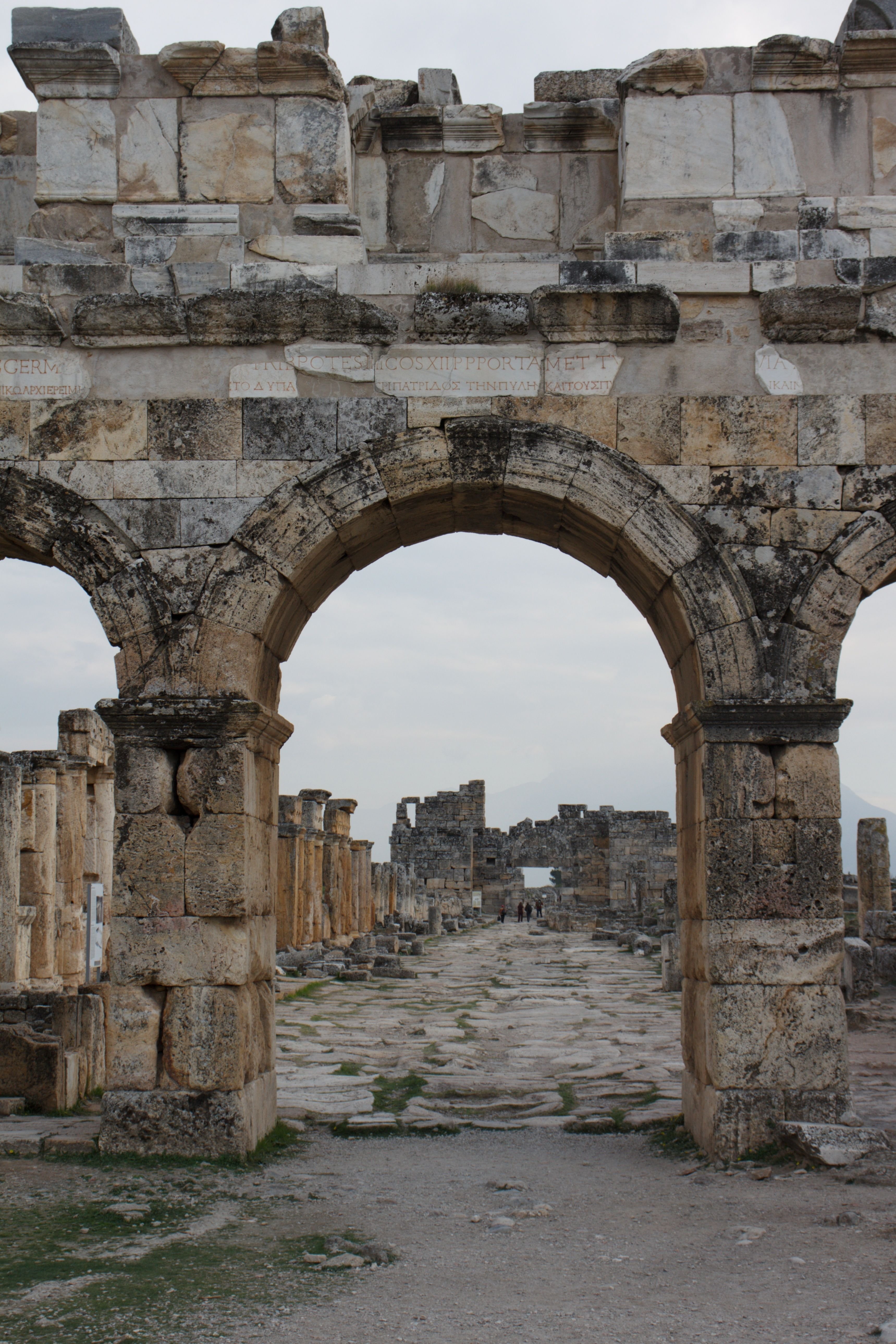 Ancient Greco-Roman theatre carved into a Turkish hillside with sea or plain beyond
