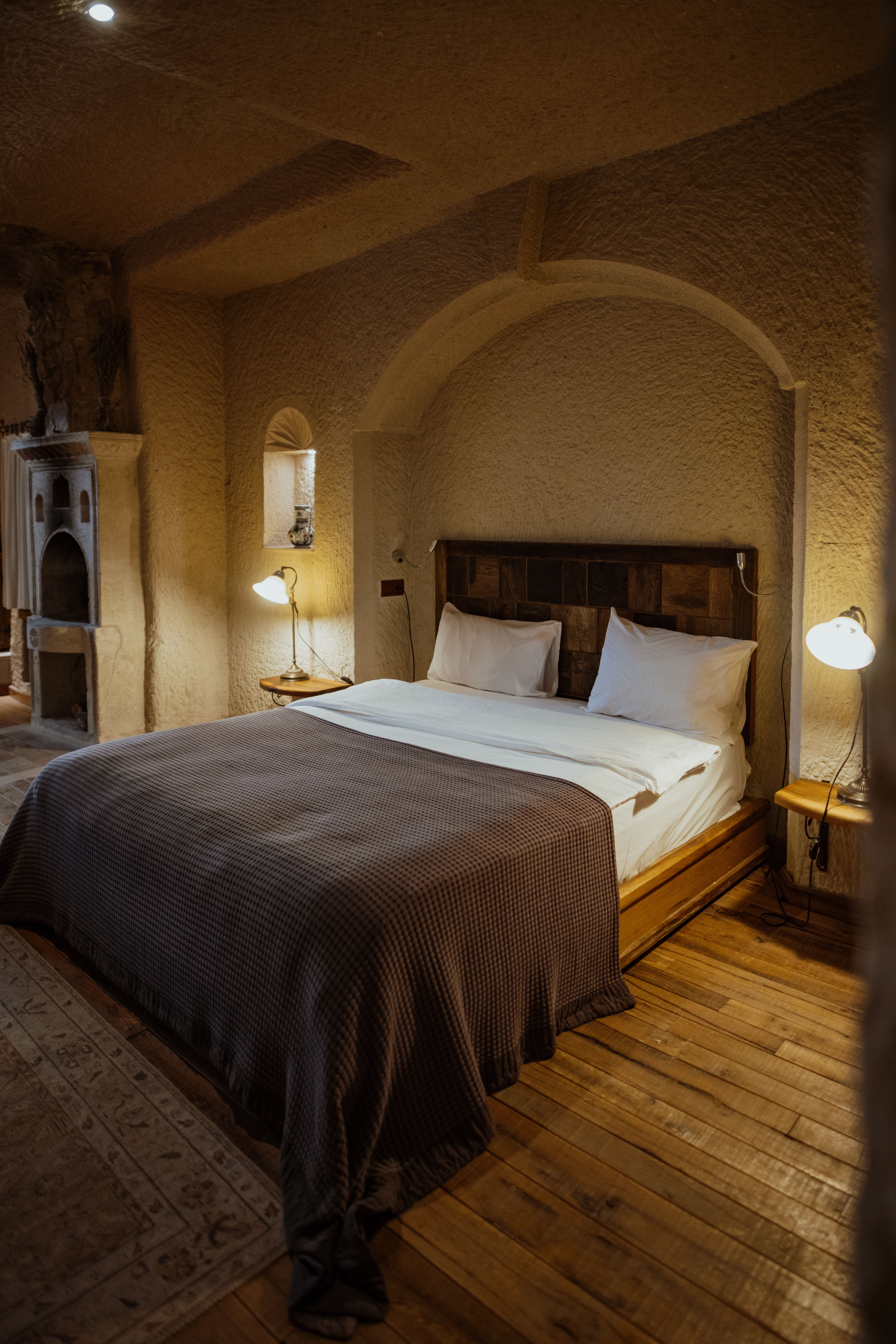 Interior of a stylish cave hotel room with arched stone ceiling and warm lighting