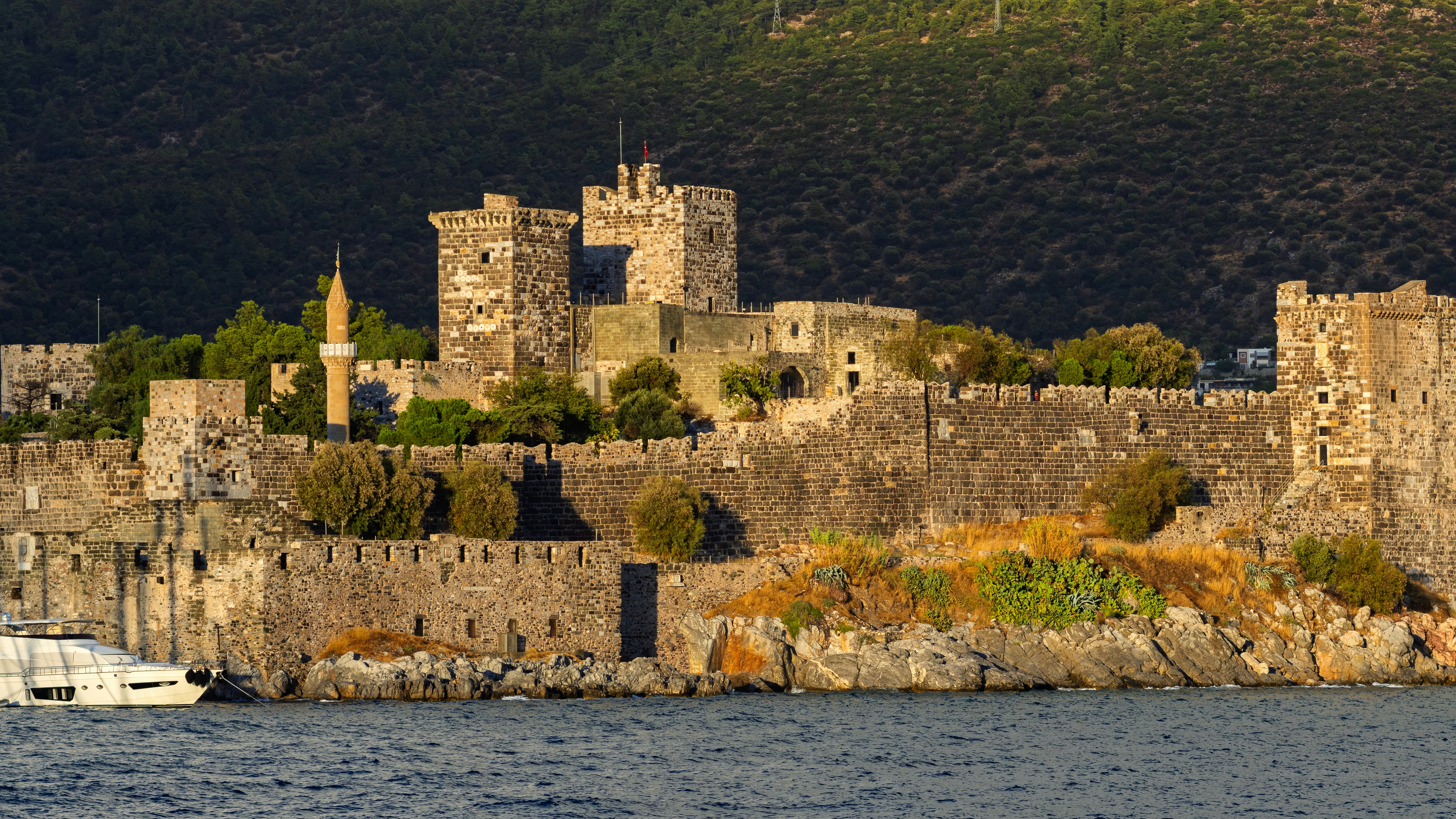 A turquoise Aegean cove near Bodrum with a wooden gulet boat anchored
