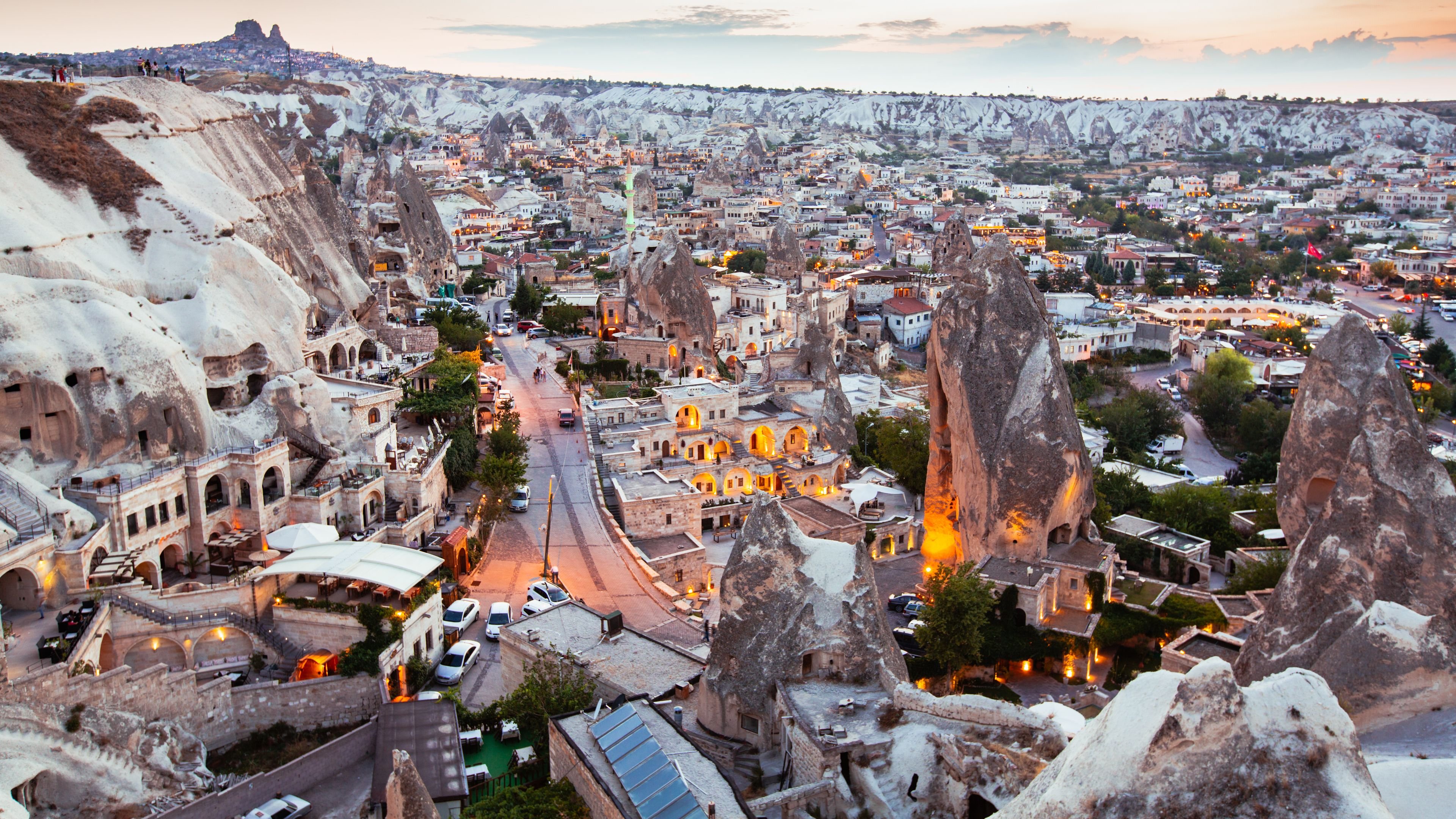 The Göreme valley at sunrise with fairy chimneys, cave dwellings, and balloons overhead