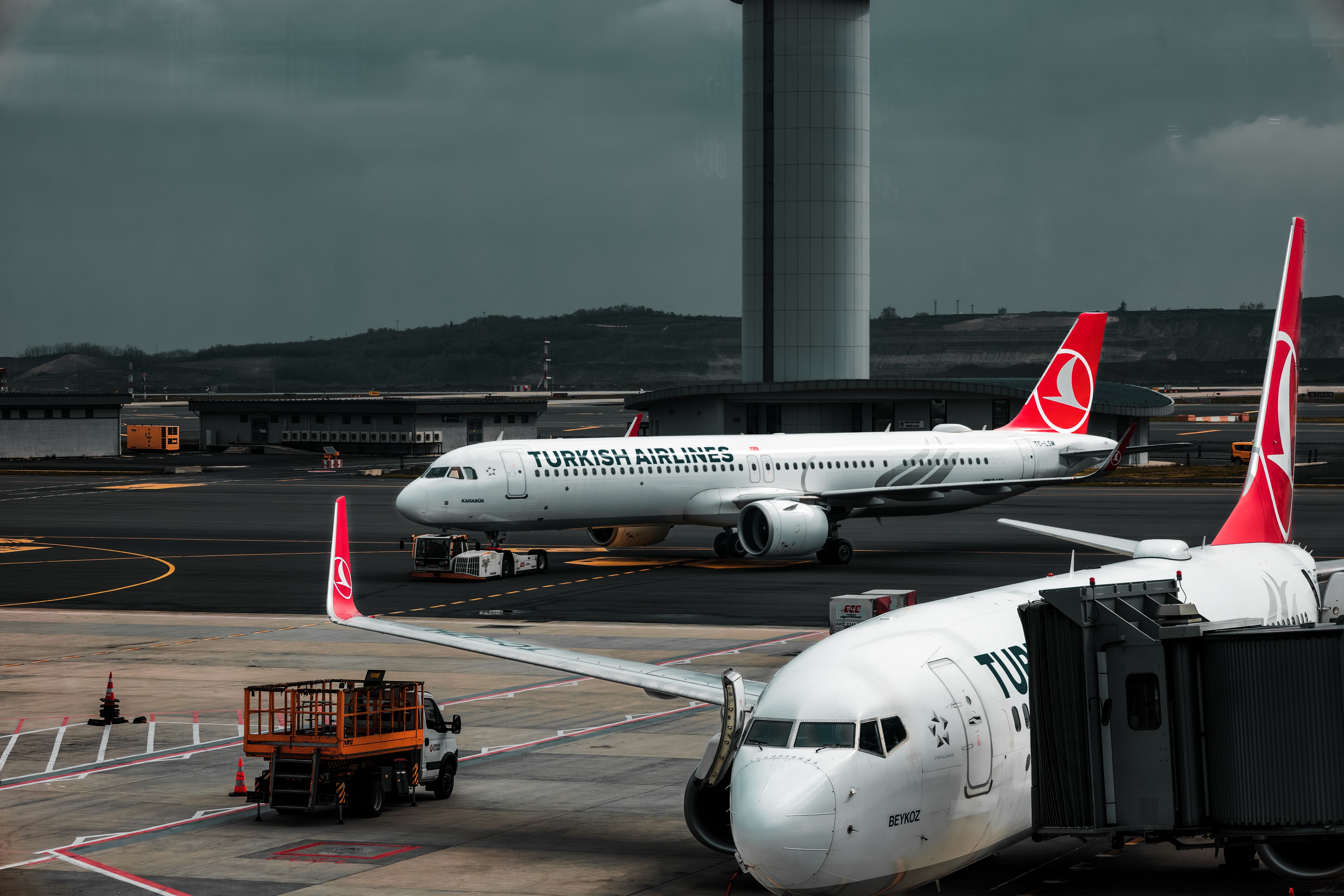 A wide-body airliner at a gate or a departures board, travel feel, no recognizable faces