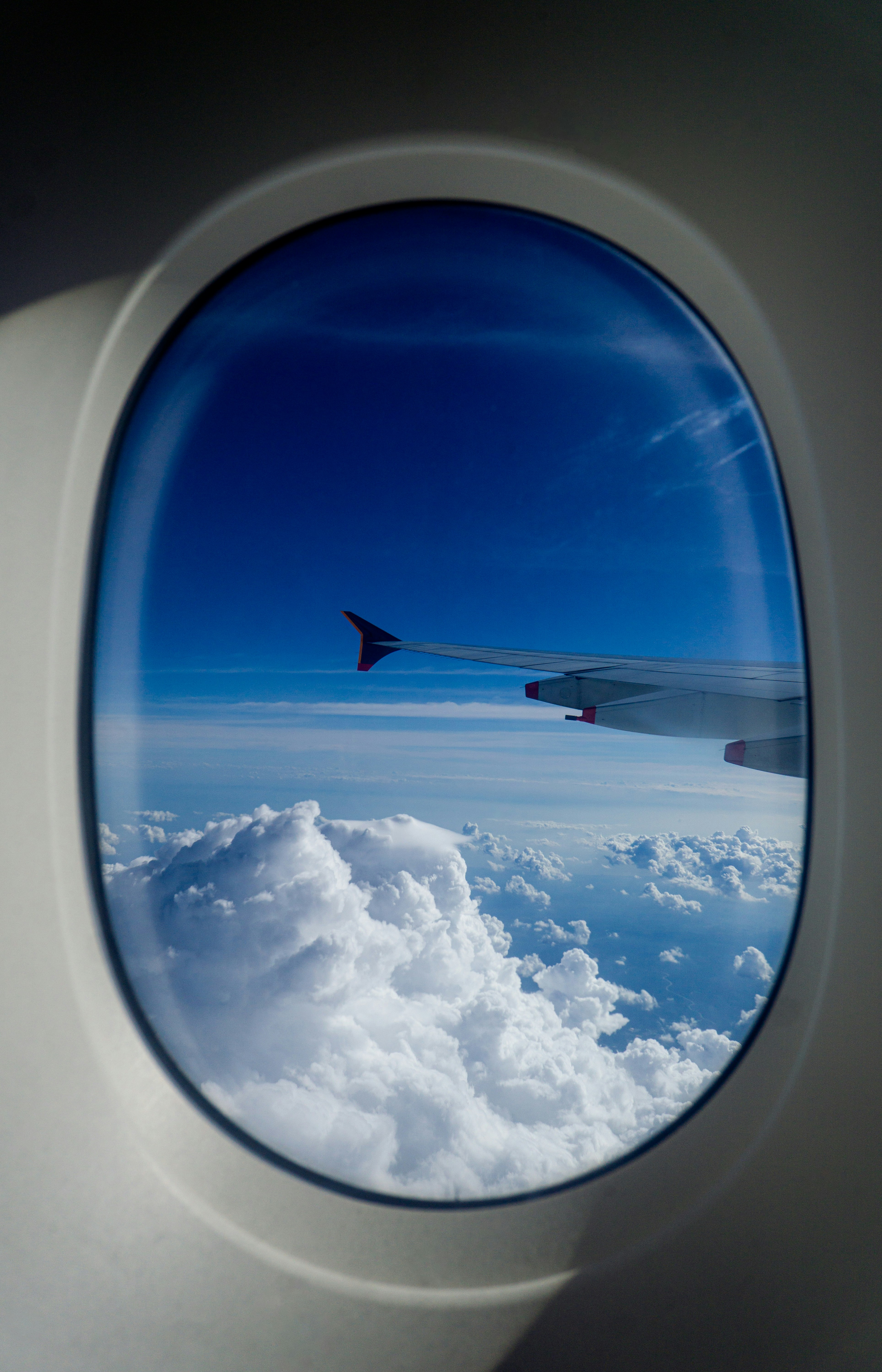 An airplane window view over clouds, sense of a long-haul journey