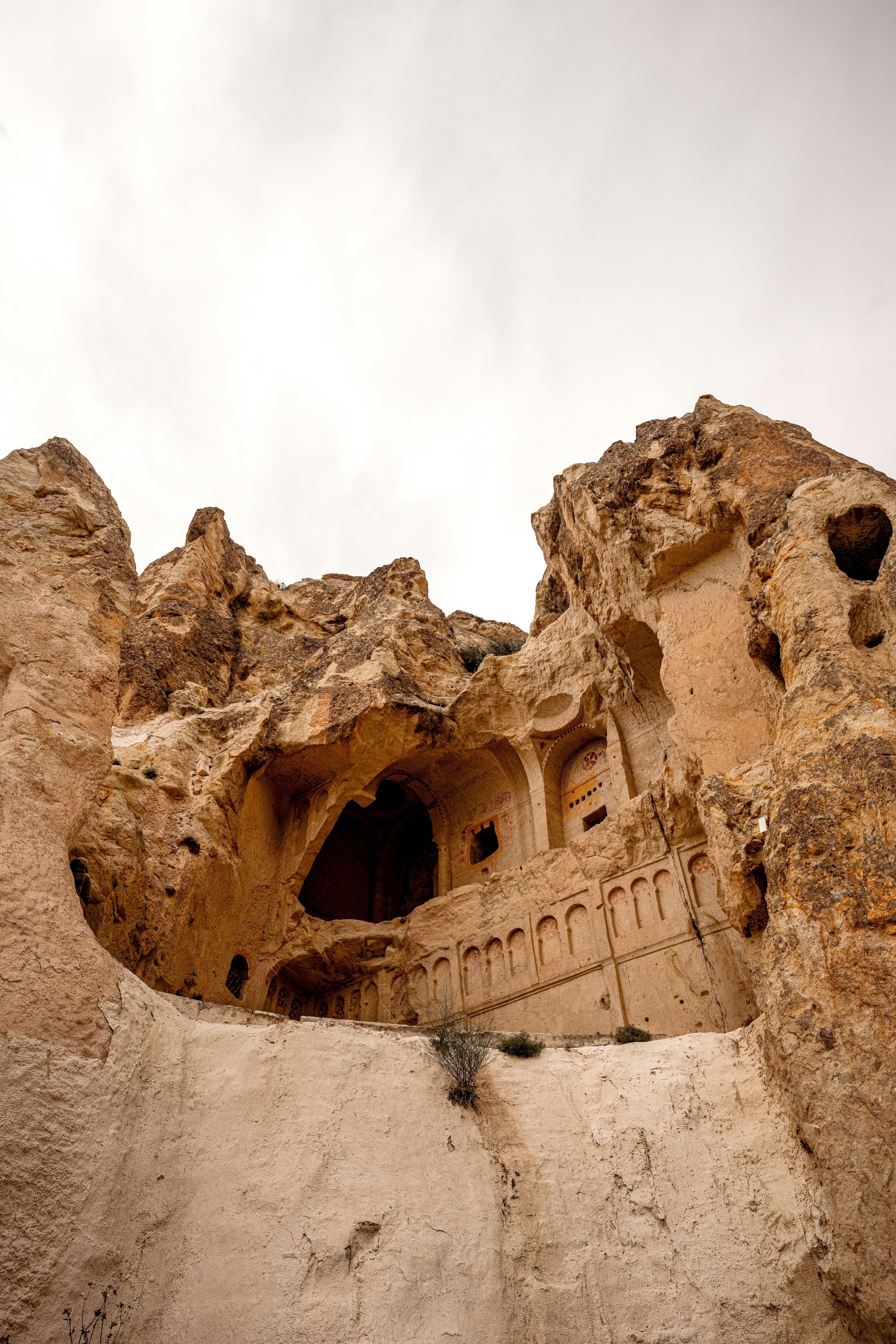 A shuttle van on a road approaching Goreme with fairy chimneys ahead