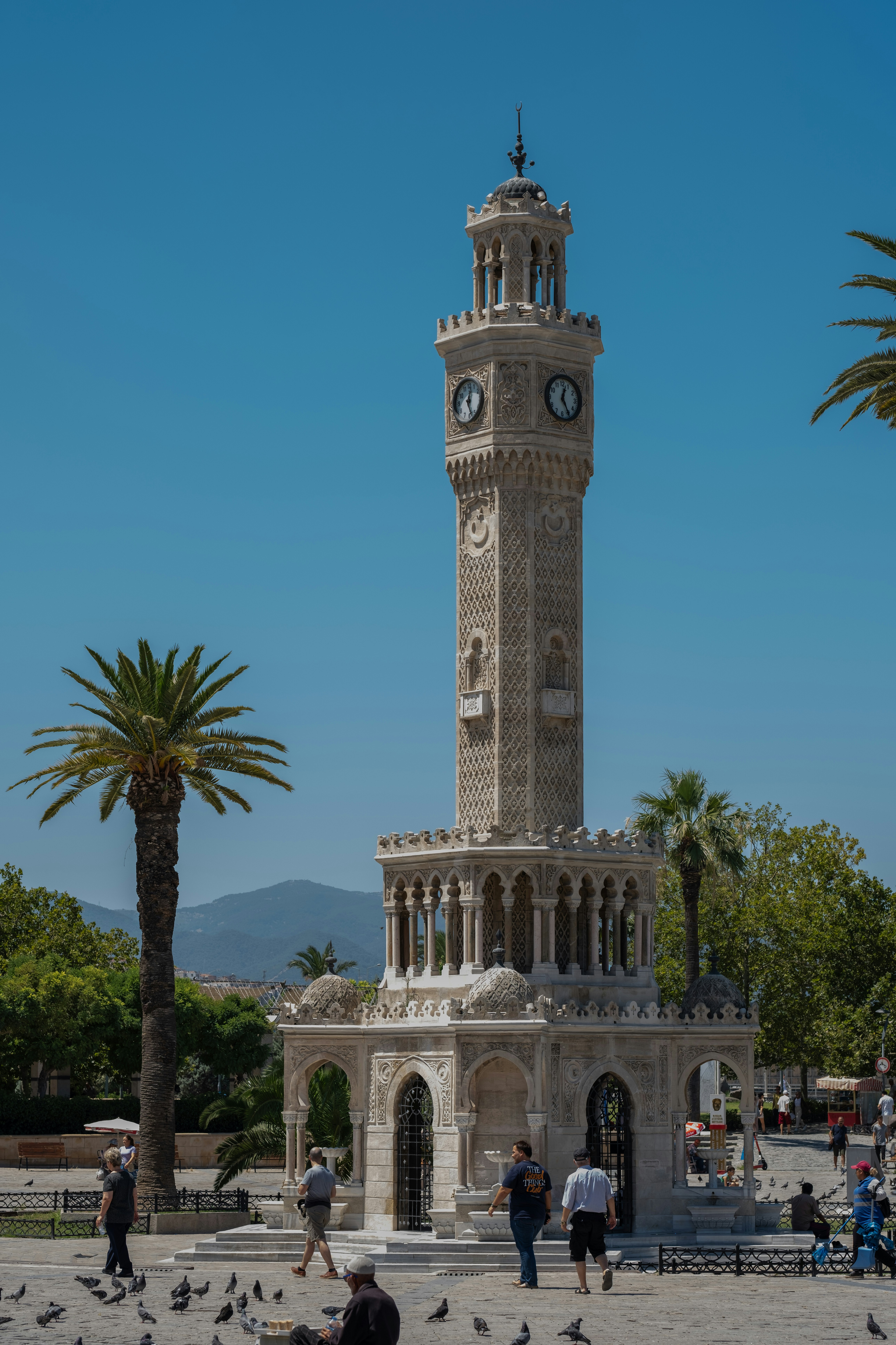 Izmir's Kordon waterfront promenade at golden hour, palm trees and the bay, no recognizable faces