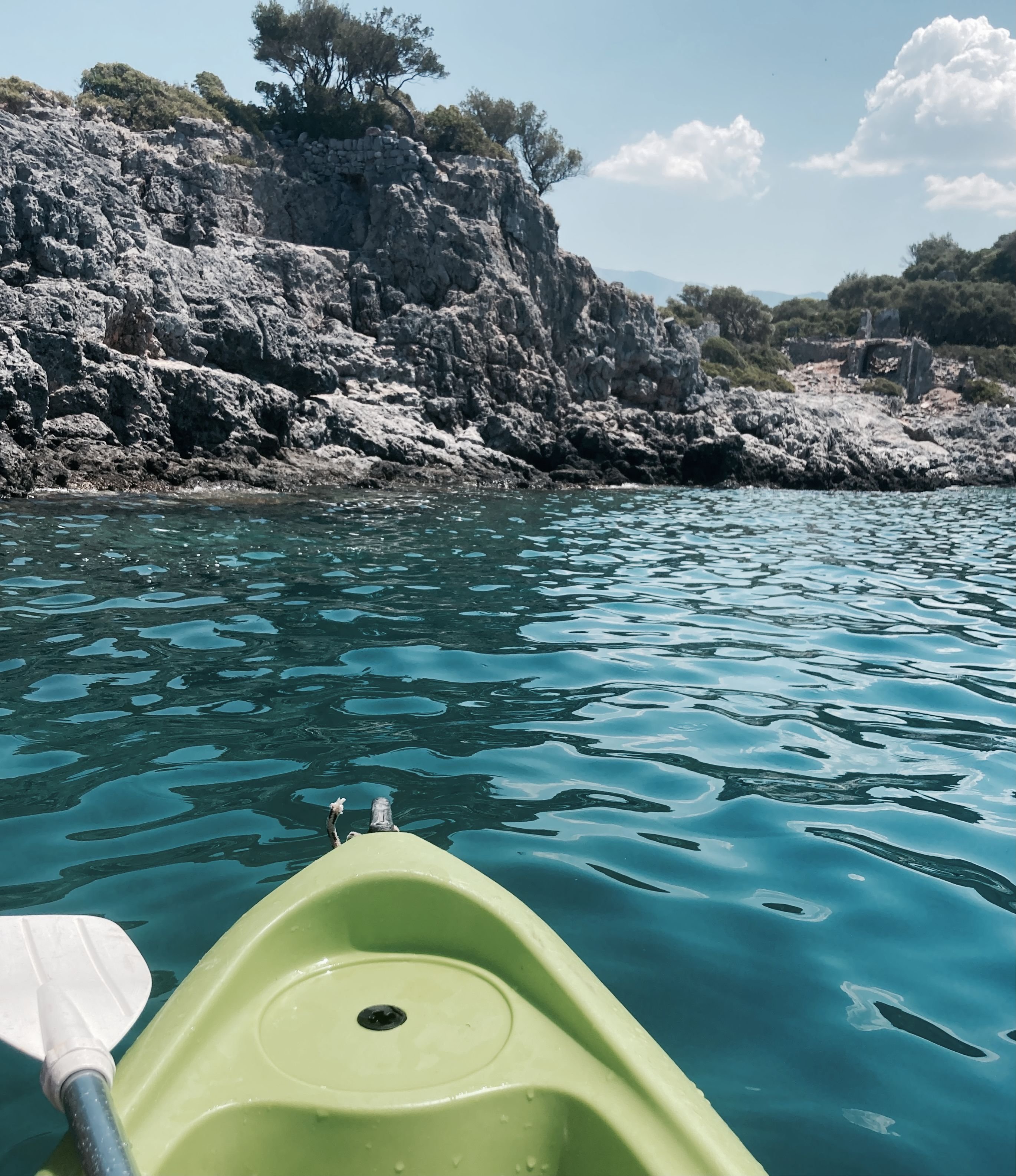 Sea kayakers paddling over the clear water of Kekova with sunken ruins visible below