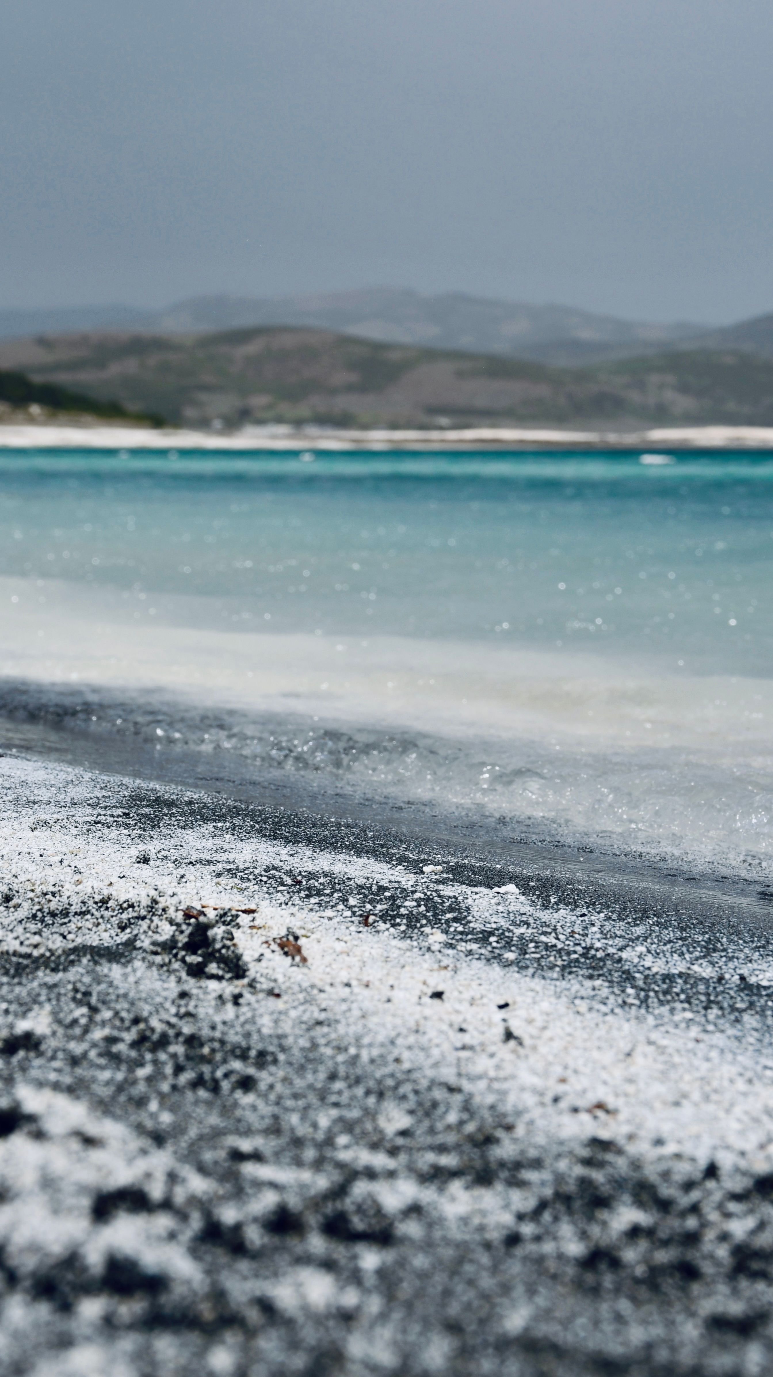 Lake Salda's white clay shoreline meeting turquoise water, hills behind, no recognizable faces