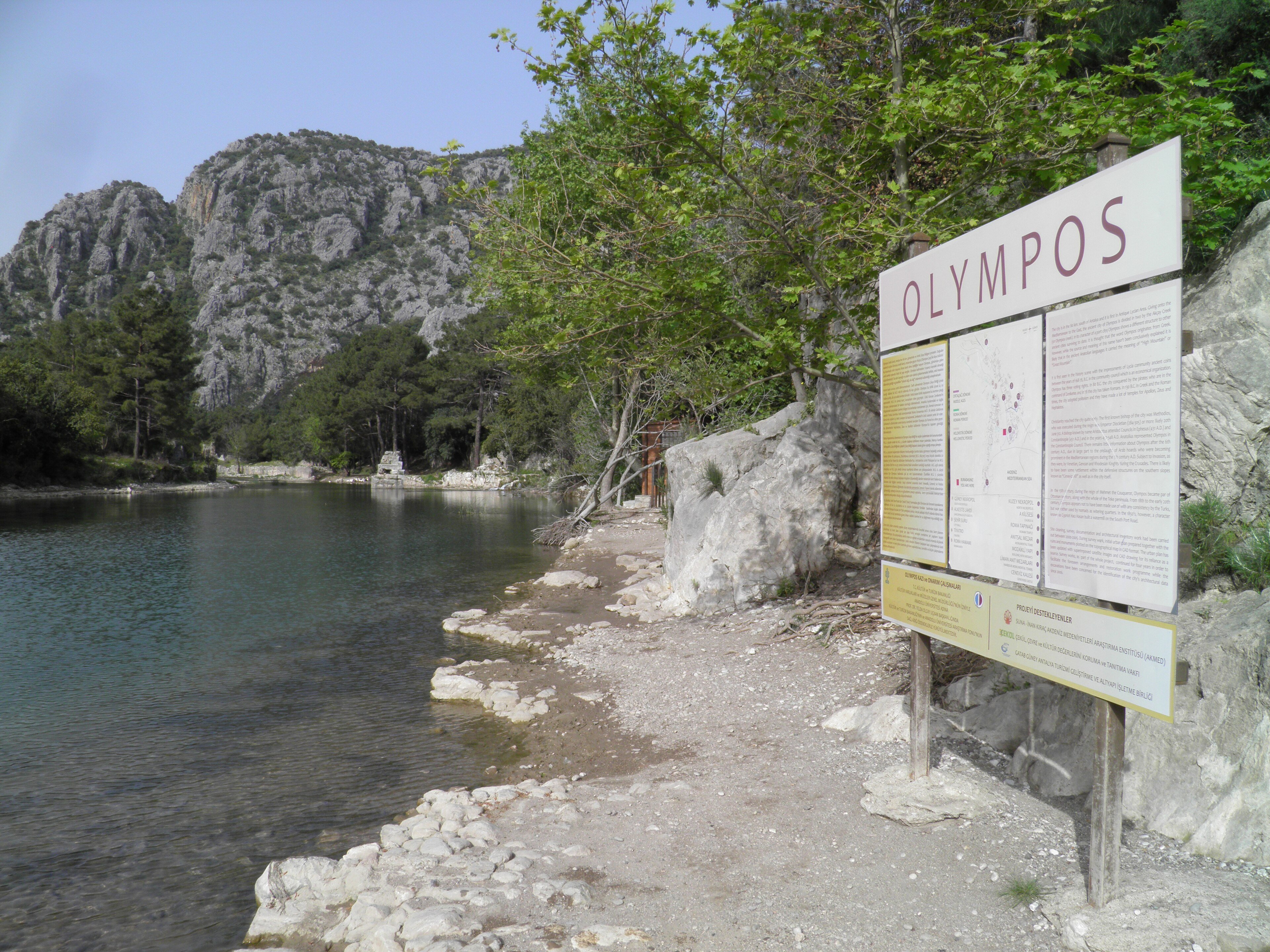 A hiker's view down to a remote turquoise cove from a Lycian Way clifftop path