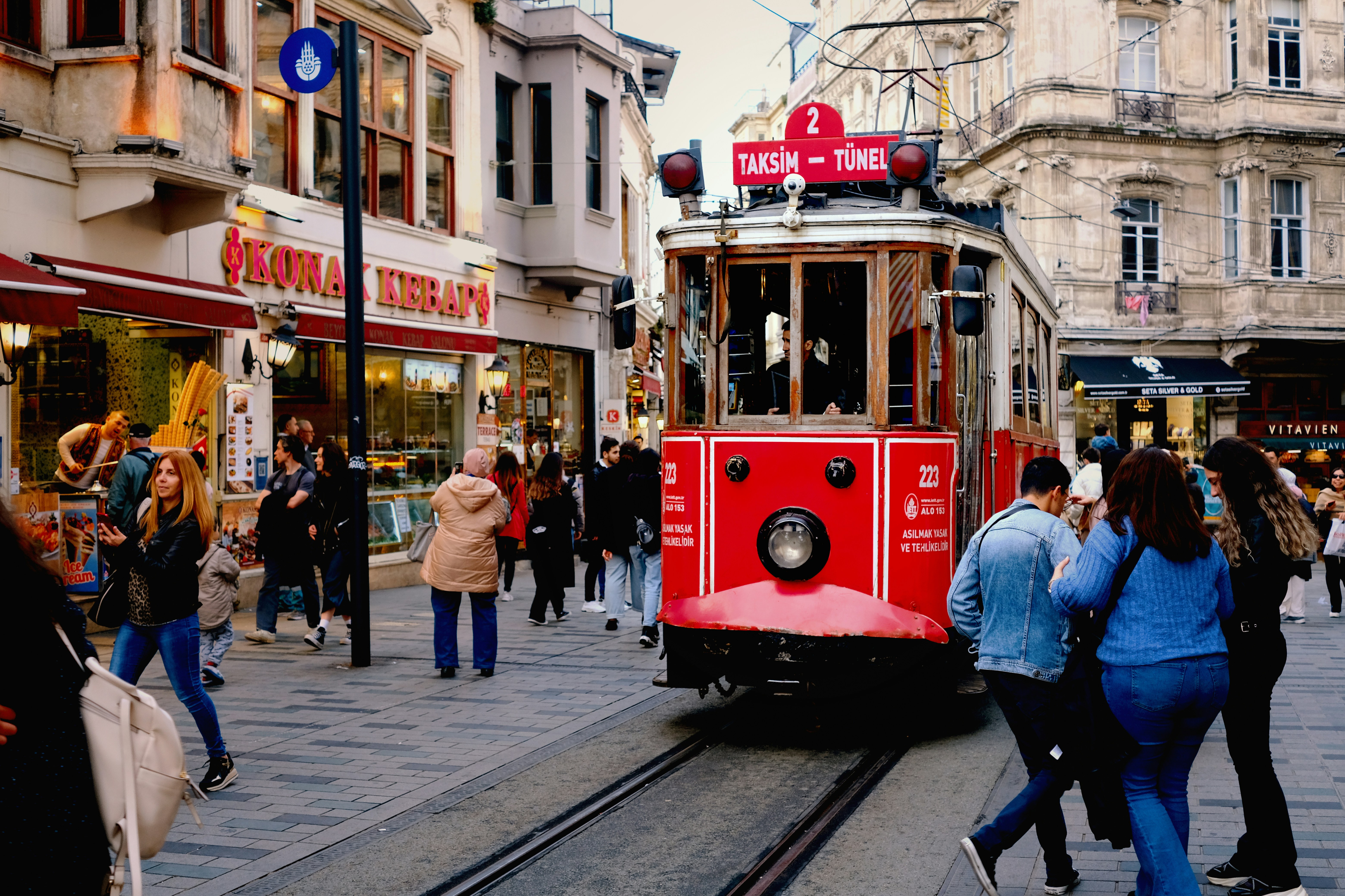 Collage-style wide shot of Istanbul life — a tram, a mosque, and a ferry on the Bosphorus