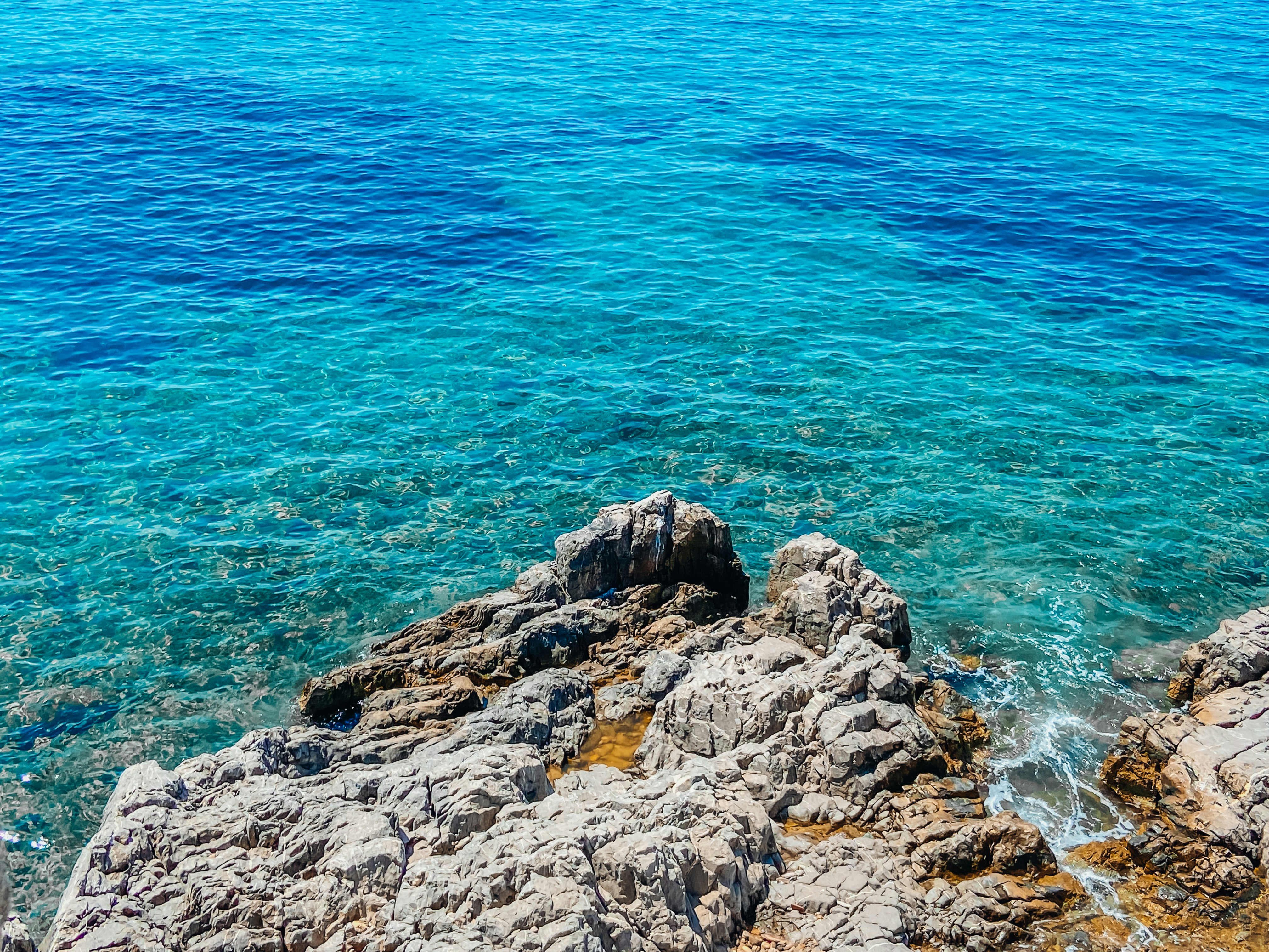 A turquoise Mediterranean bay or a gulet, representing the longer-trip coast