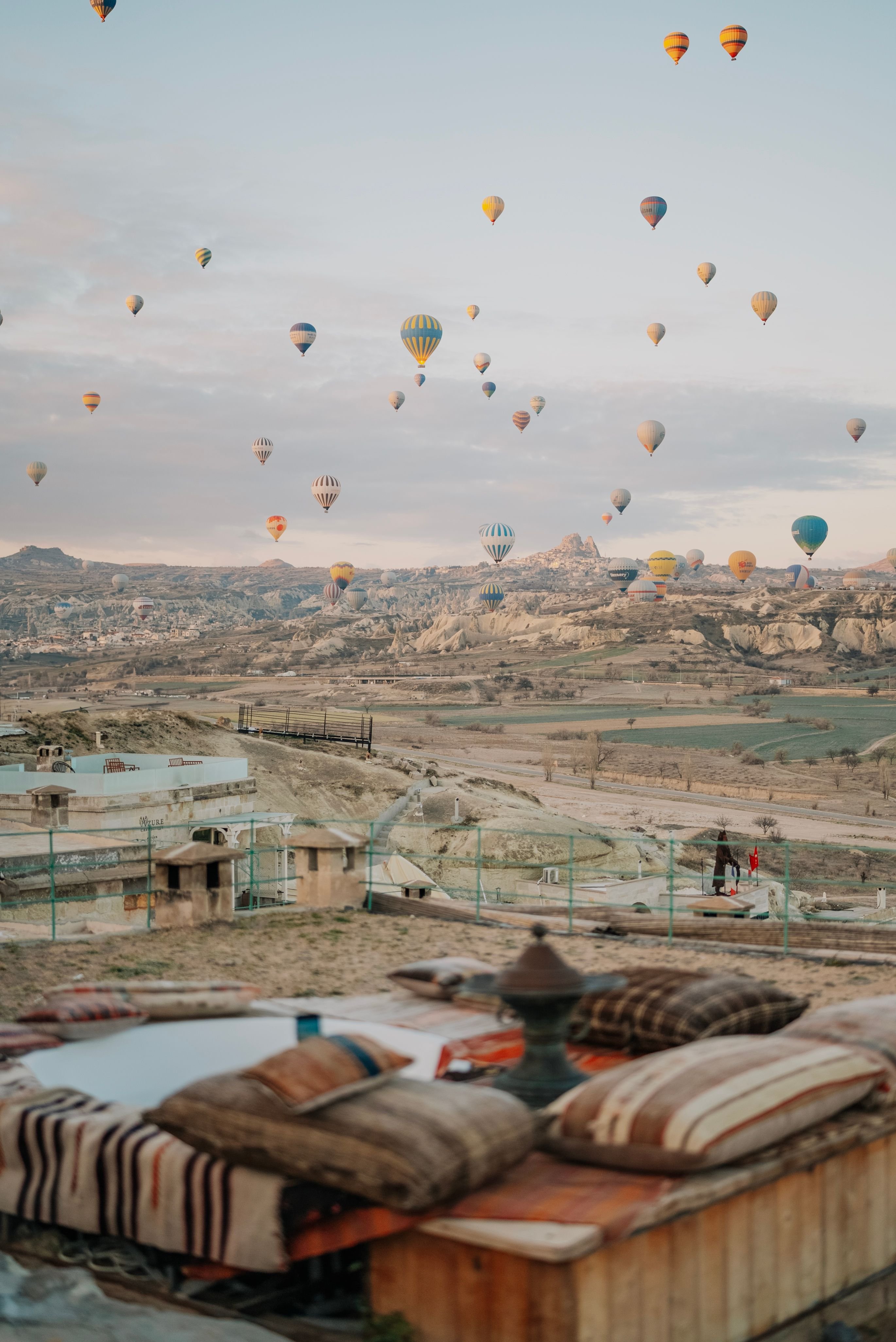 Cappadocia cave hotel terrace at sunrise with balloons in the distance