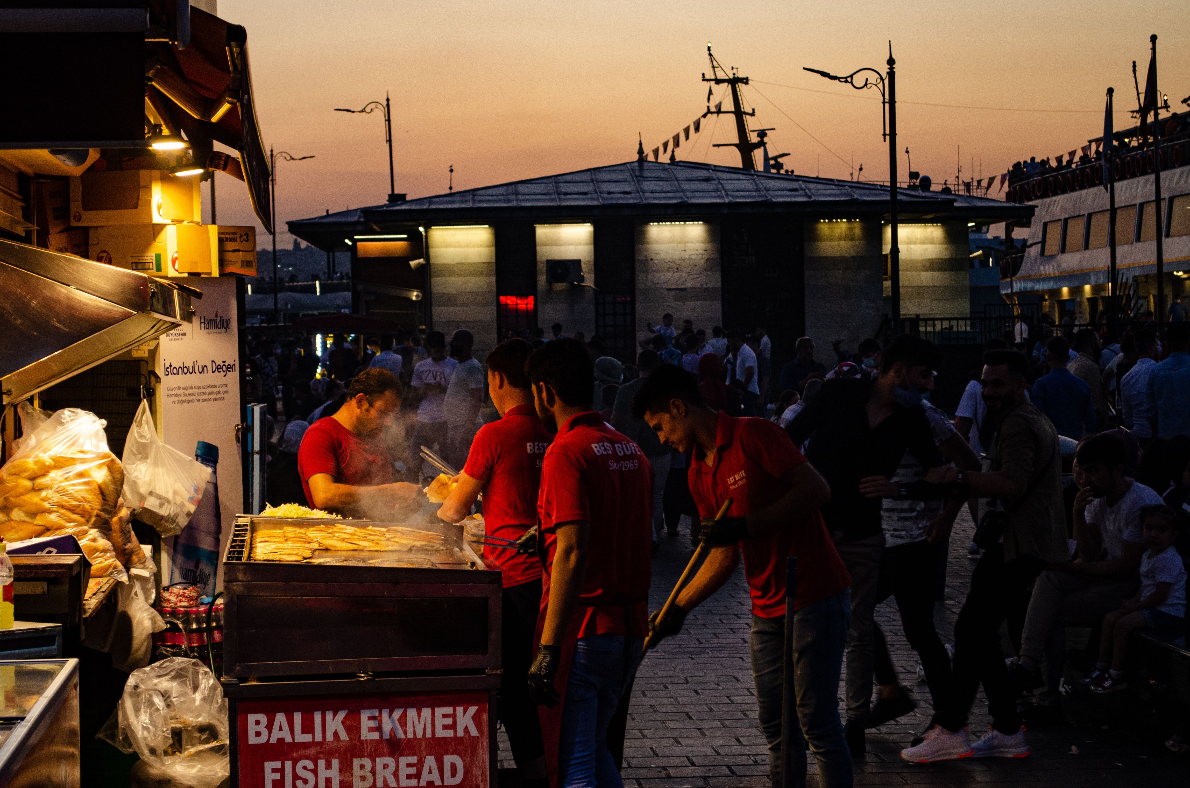 A Turkish street food cart with simit bread rings stacked, city street behind, no recognizable faces
