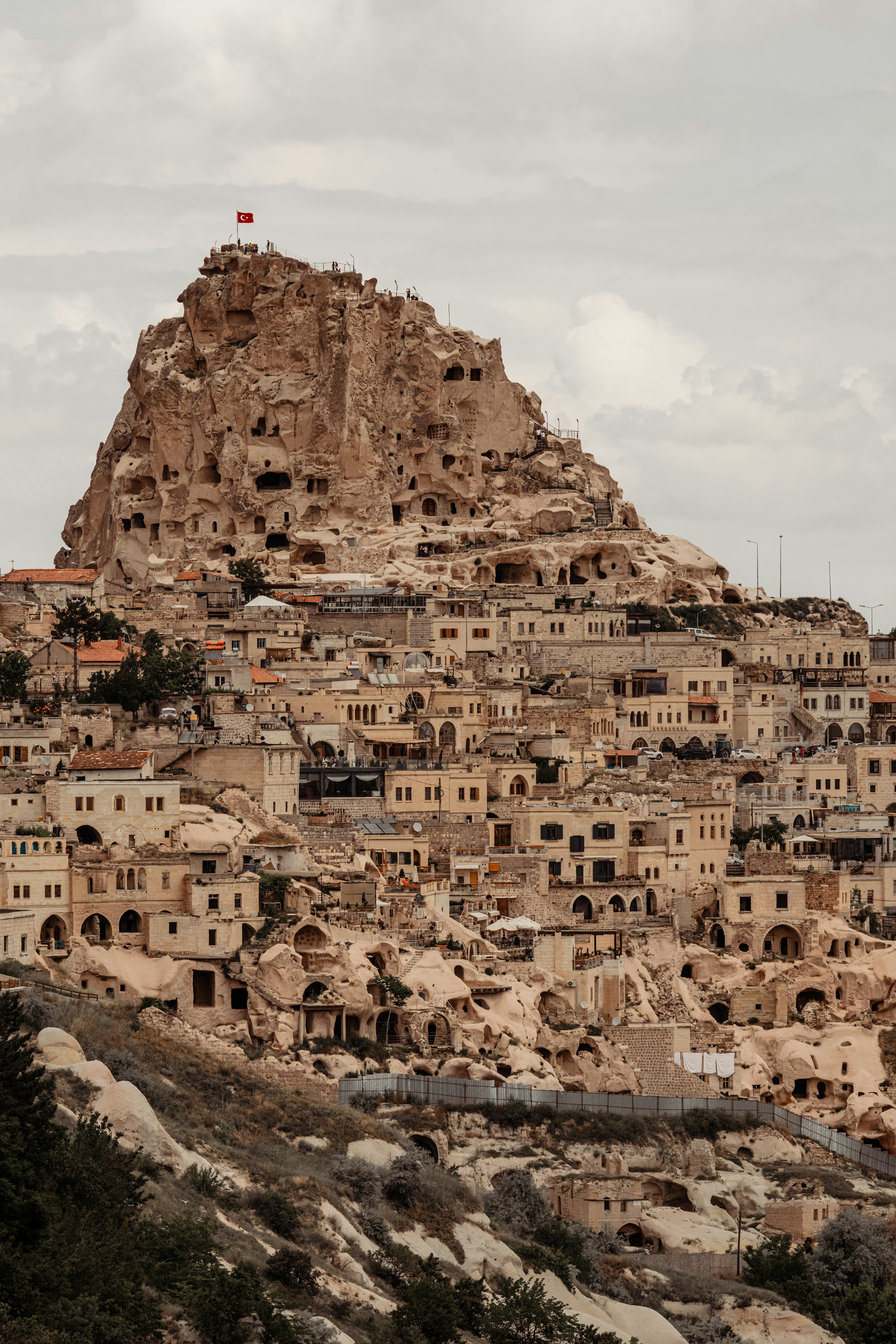 Uchisar Castle rising above cave dwellings with the valley stretching behind